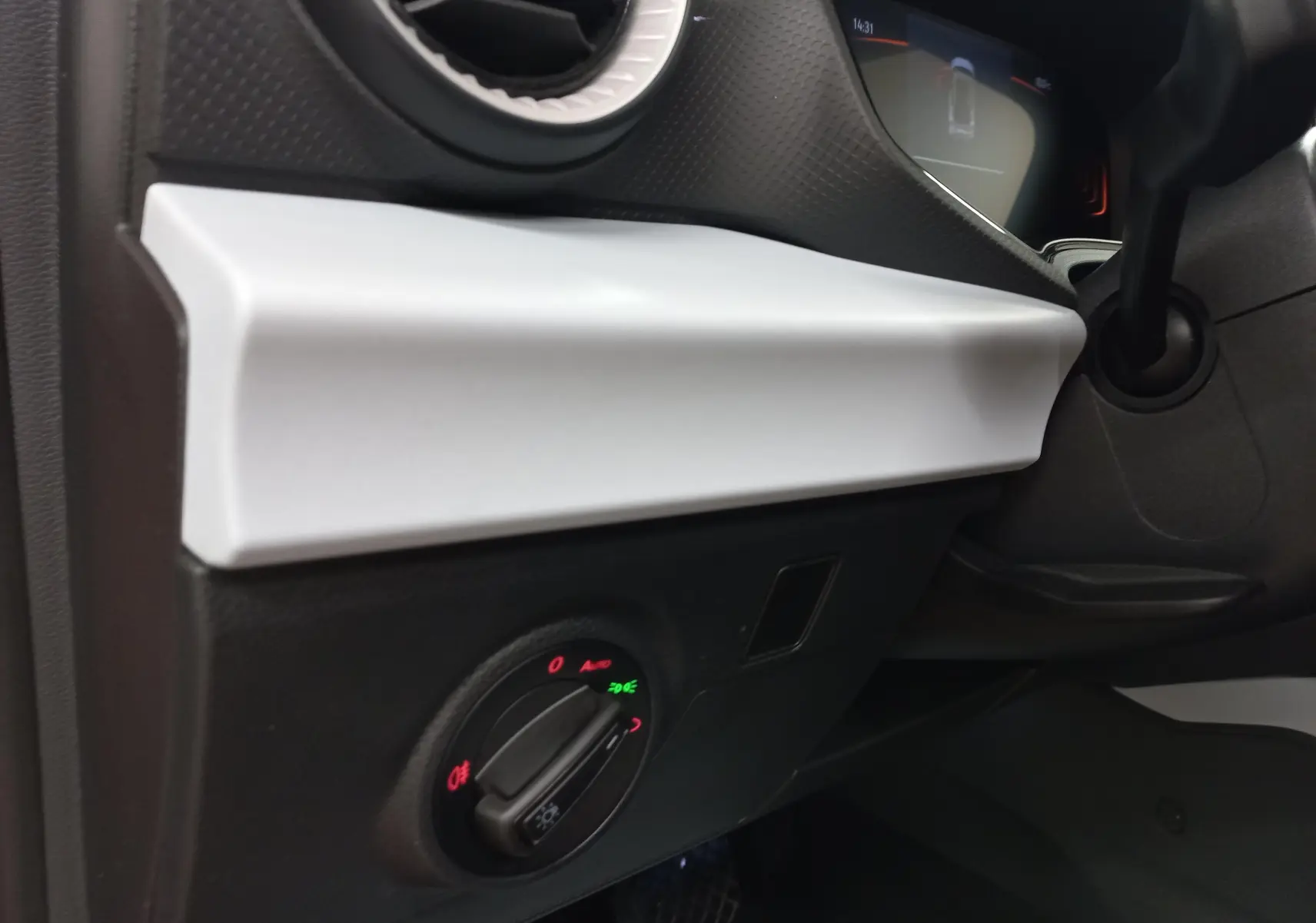Détail intérieur côté gauche du tableau de bord du SEAT Arona 2025 avec commande des phares et finition blanche.