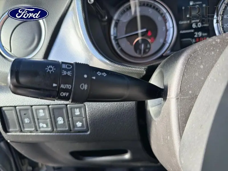 Gros plan sur la commande des phares et clignotants à gauche du volant d’un Suzuki Vitara Galactic Gray.