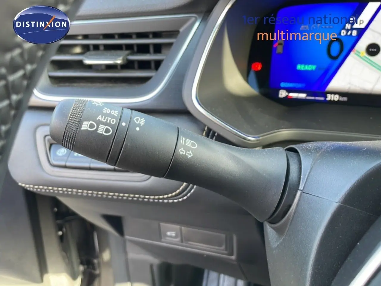 Gros plan sur la manette de commande des phares et clignotants à gauche du volant dans l'habitacle du Renault Symbioz gris cassiopée.