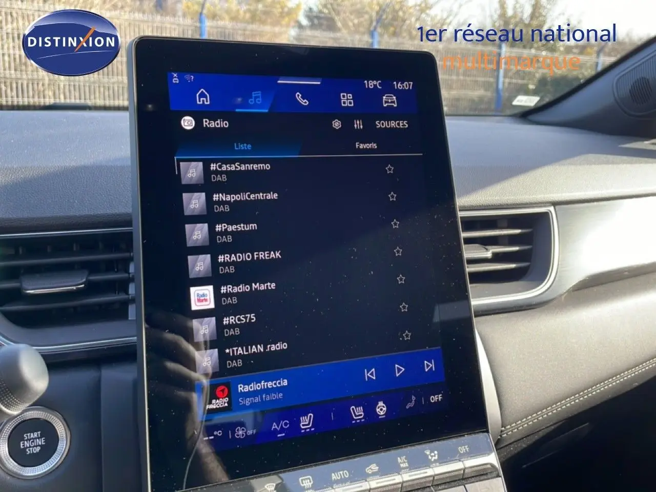 Vue intérieure centrée sur l’écran tactile du tableau de bord du Renault Symbioz gris cassiopée, affichant les stations radio.
