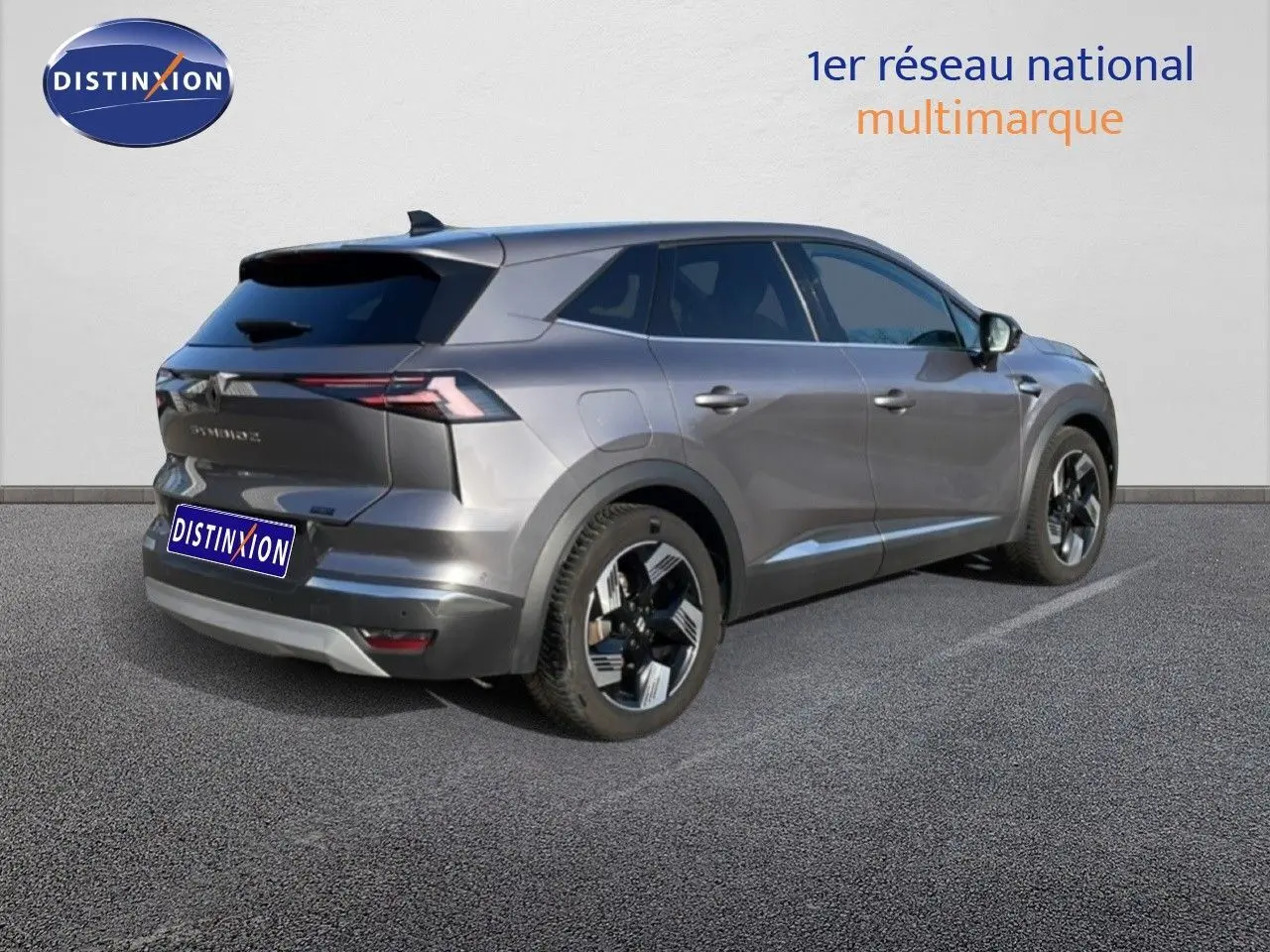 Renault Symbioz gris cassiopée métal, vue 3/4 arrière droit, SUV hybride avec jantes modernes et feux LED fins.