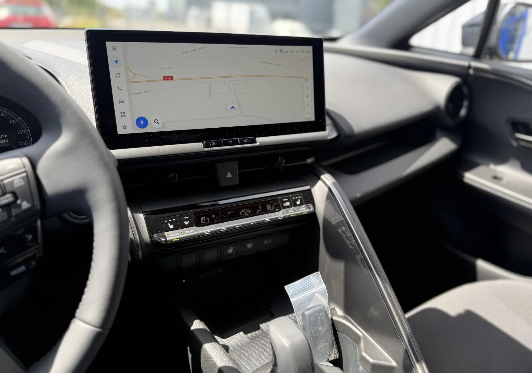 Vue intérieure du tableau de bord du Toyota C-HR 1.8 Hybride 2025, avec écran tactile et console centrale noire moderne.