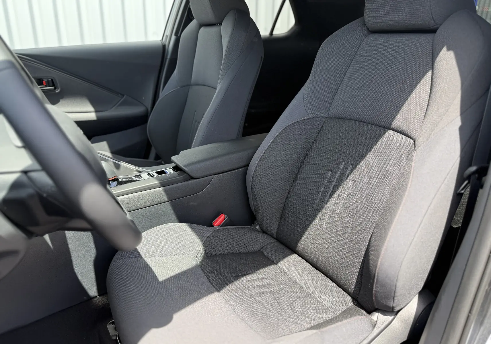 Vue rapprochée des sièges avant en tissu gris du Toyota C-HR 1.8 Hybride 140 Style 2025, côté conducteur.
