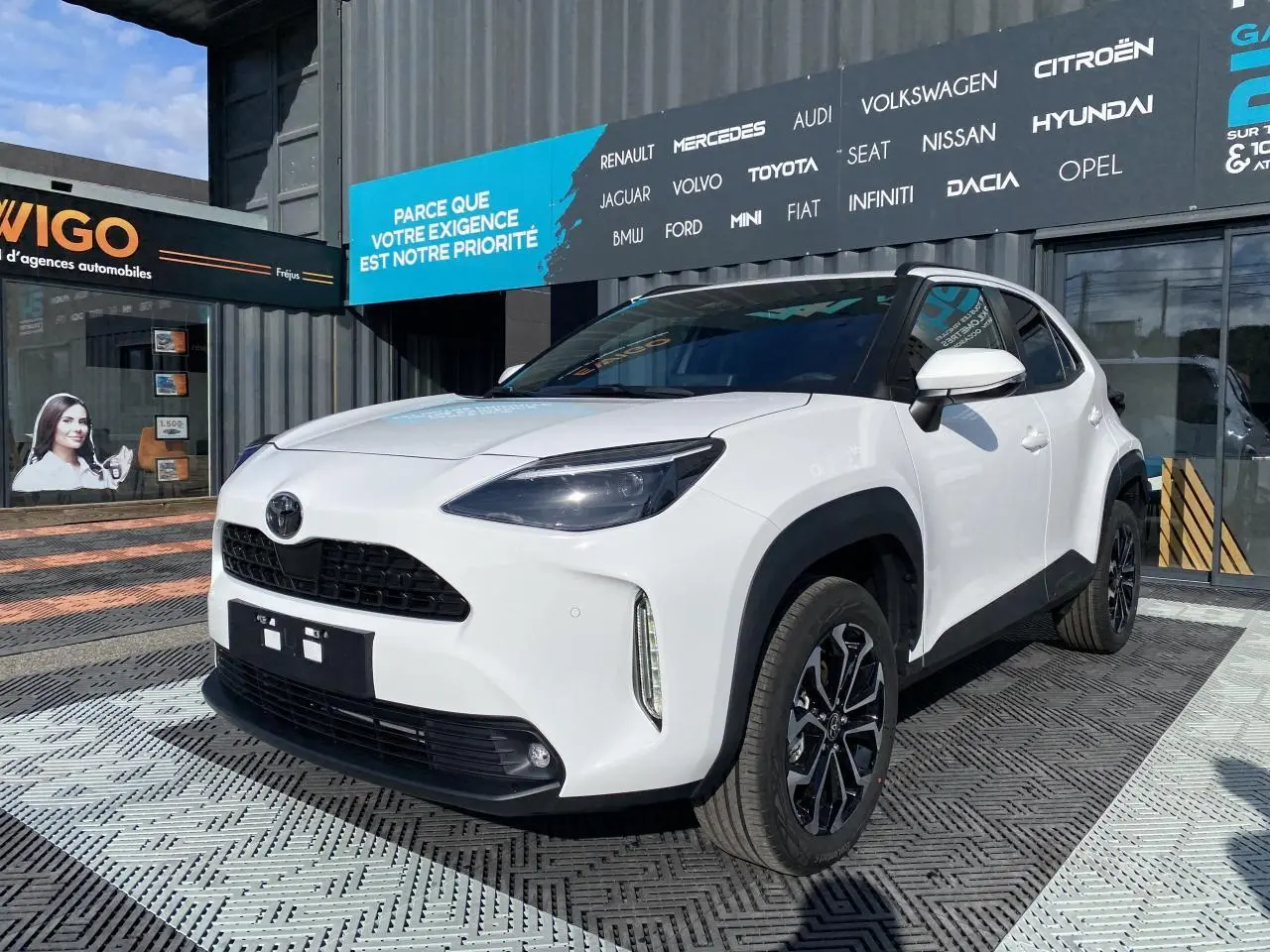 Toyota Yaris Cross blanc pur vue 3/4 avant droit avec jantes alliage noires et toit noir contrasté.