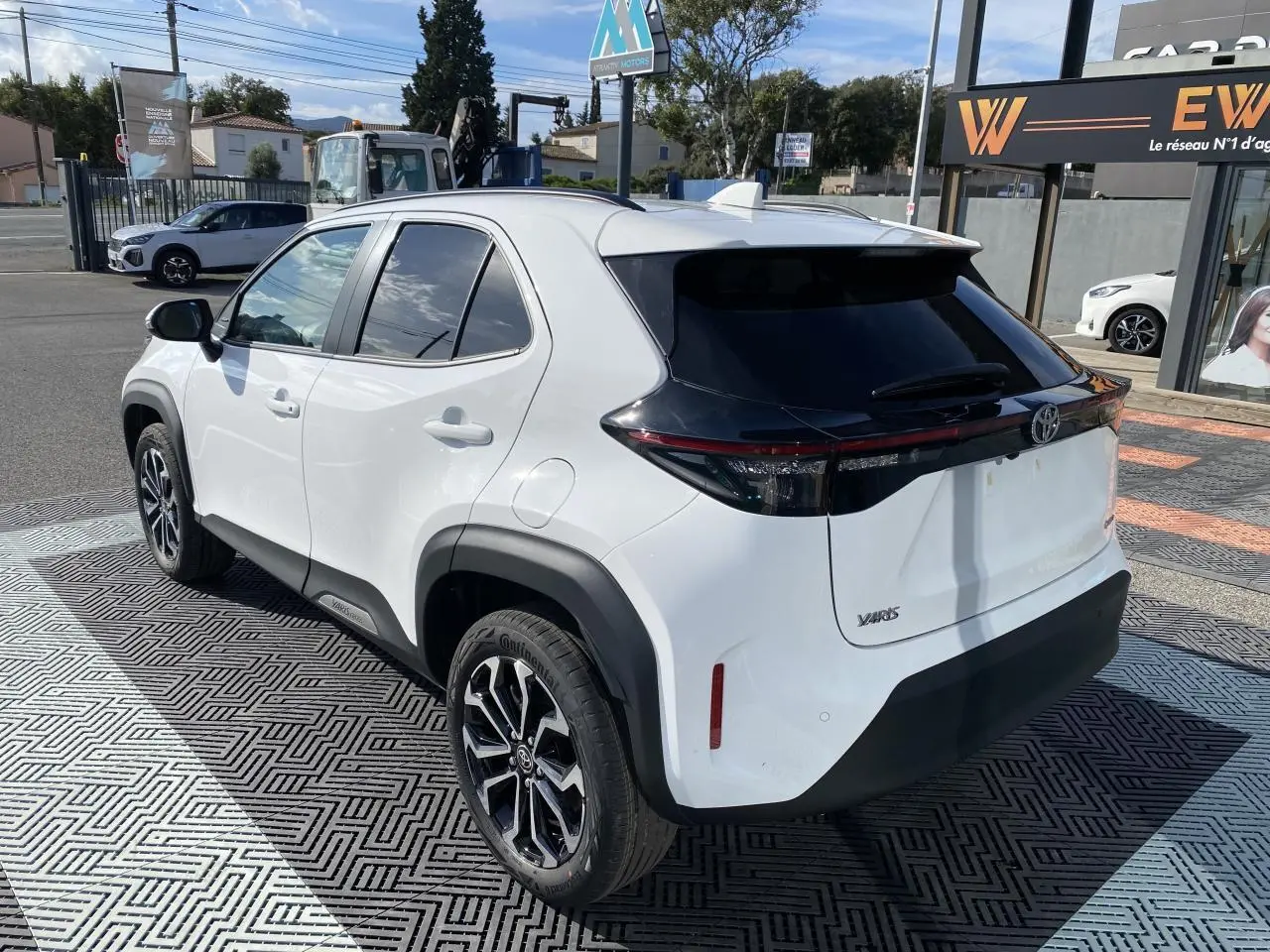 Vue 3/4 arrière droite d'une Toyota Yaris Cross blanche avec toit noir et jantes alliage 17 pouces.