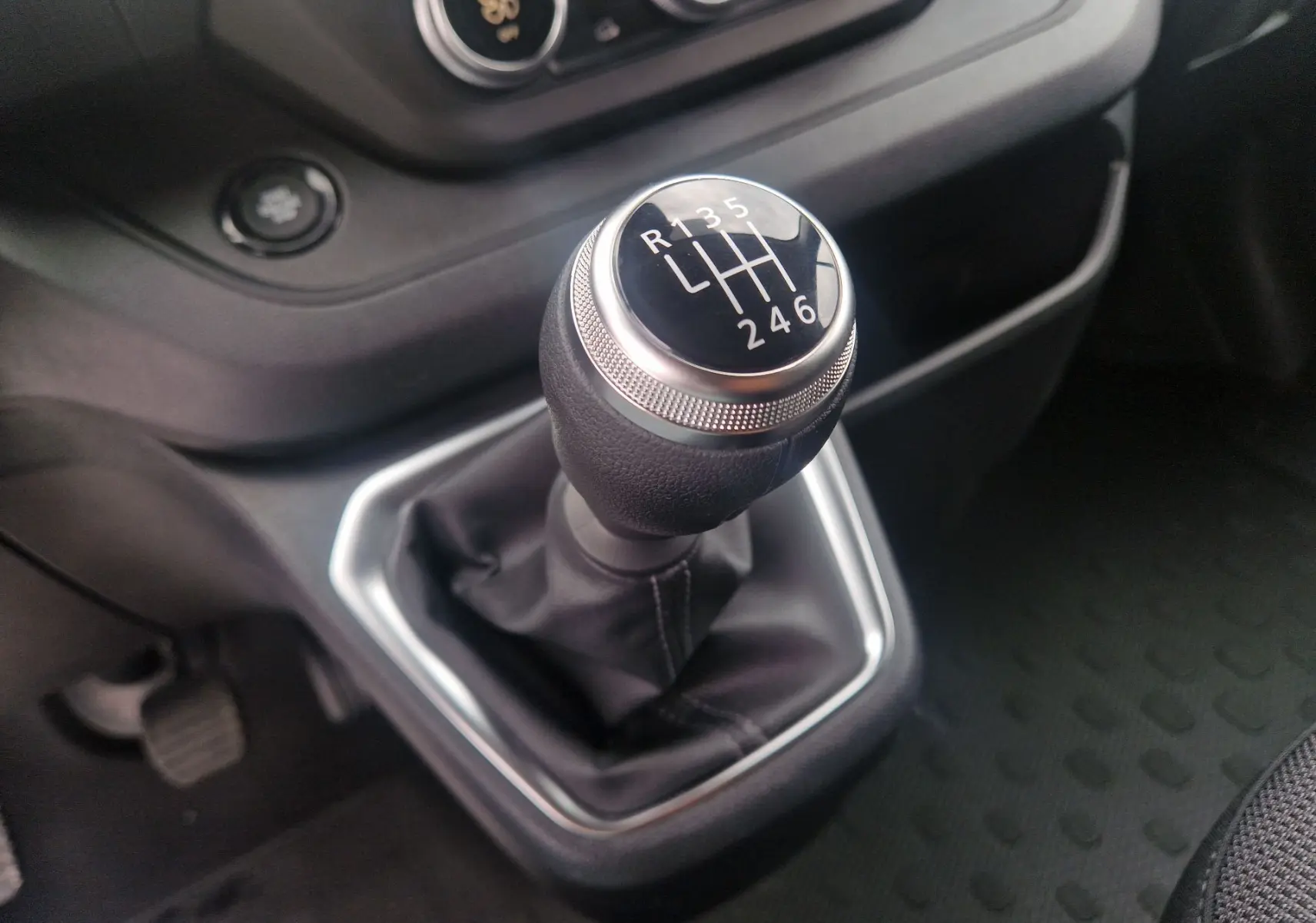 Le levier de vitesses manuel du Renault Trafic Fourgon gris urbain, vue rapprochée de la console centrale.