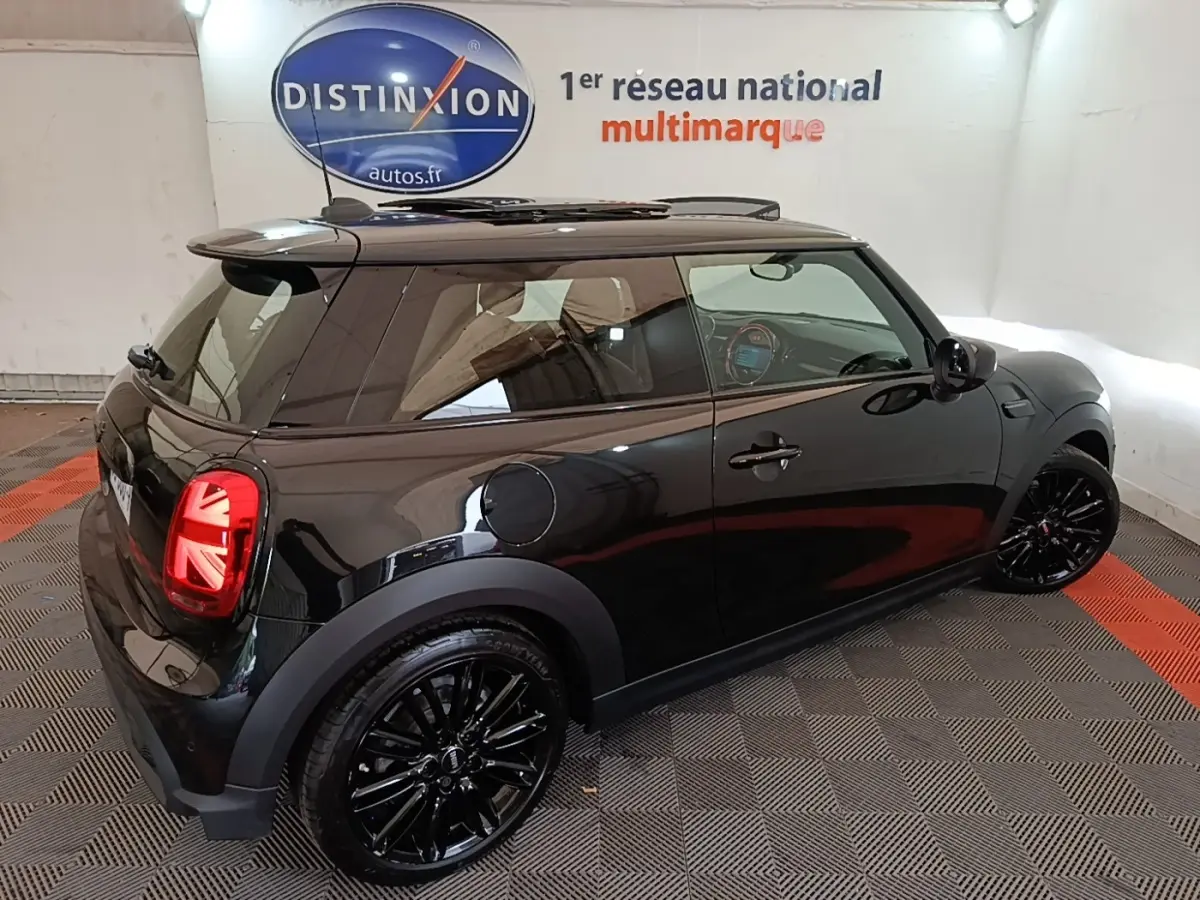 Mini Cooper Edition Premium Plus noire vue en 3/4 arrière droit, avec jantes noires et feux arrière à motif Union Jack.