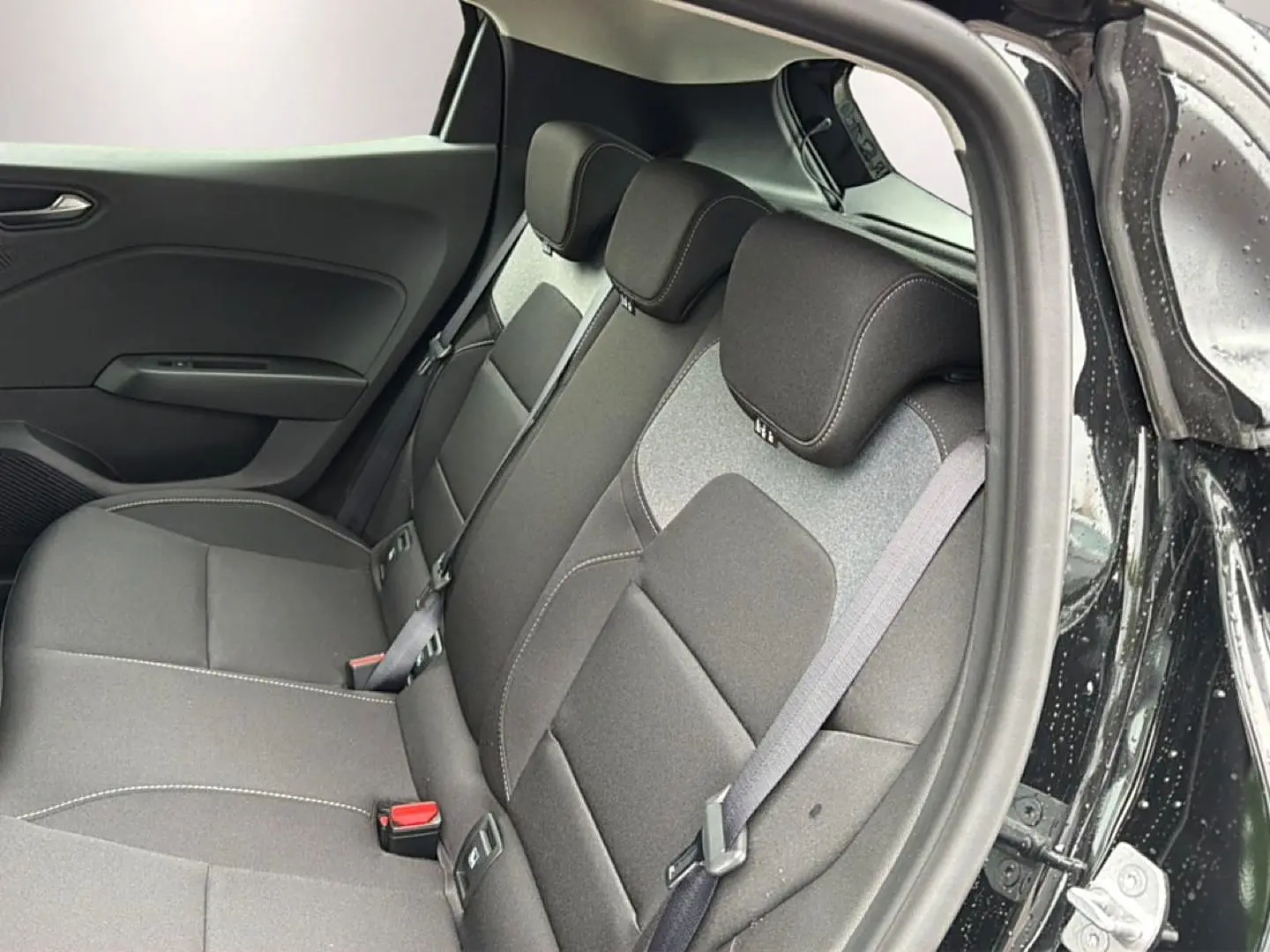 Vue intérieure côté droit de la banquette arrière noire de la Renault Clio V 1.0 TCe 90 Evolution 2026 avec ceintures visibles.