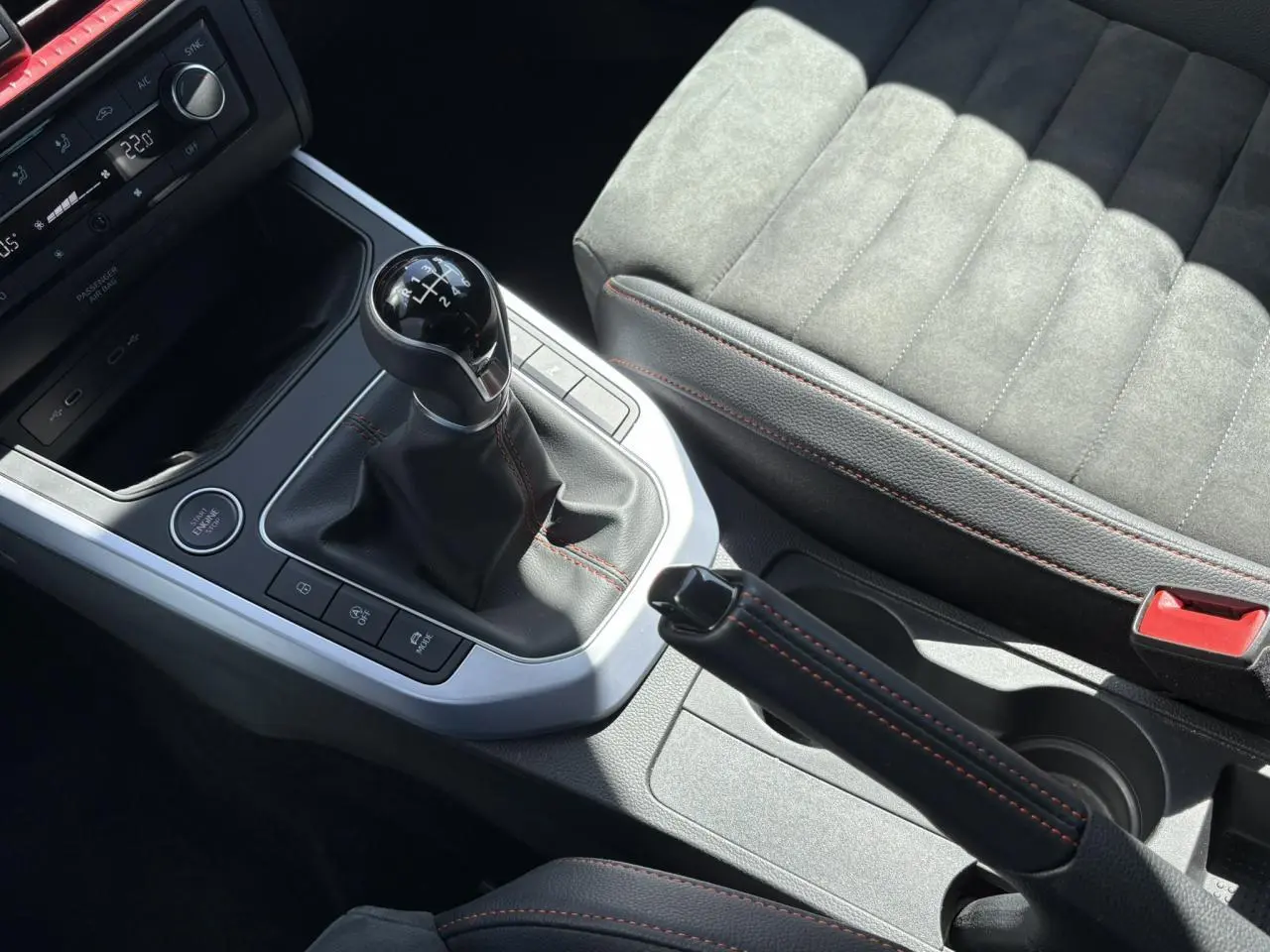 Gros plan sur la console centrale du SEAT Arona TSI 110 FR 2024, avec levier de vitesse manuel et sellerie suédine grise.