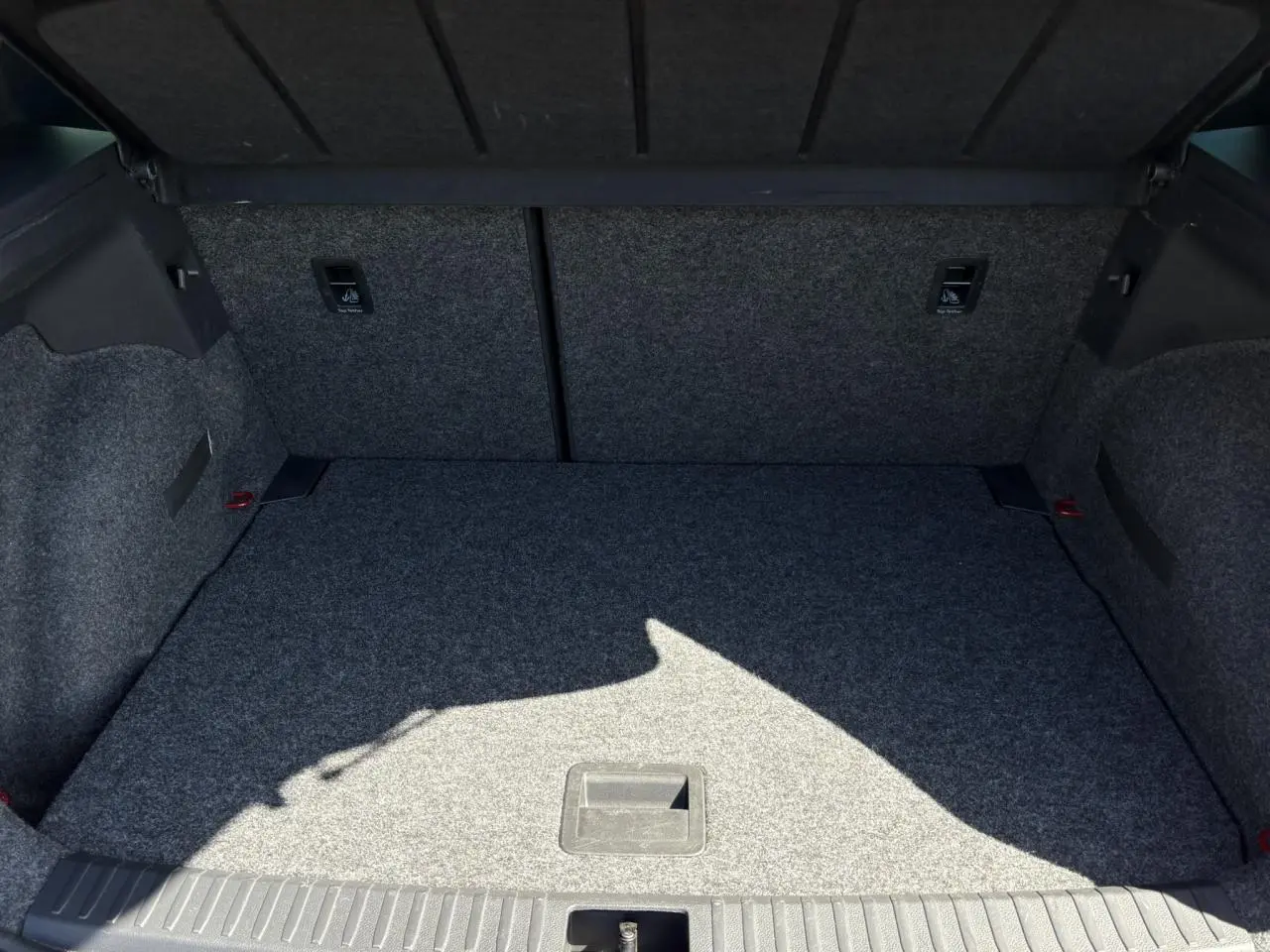 Coffre spacieux et tapissé en gris du SEAT Arona TSI 110 FR 2024, vue intérieure arrière ouverte.