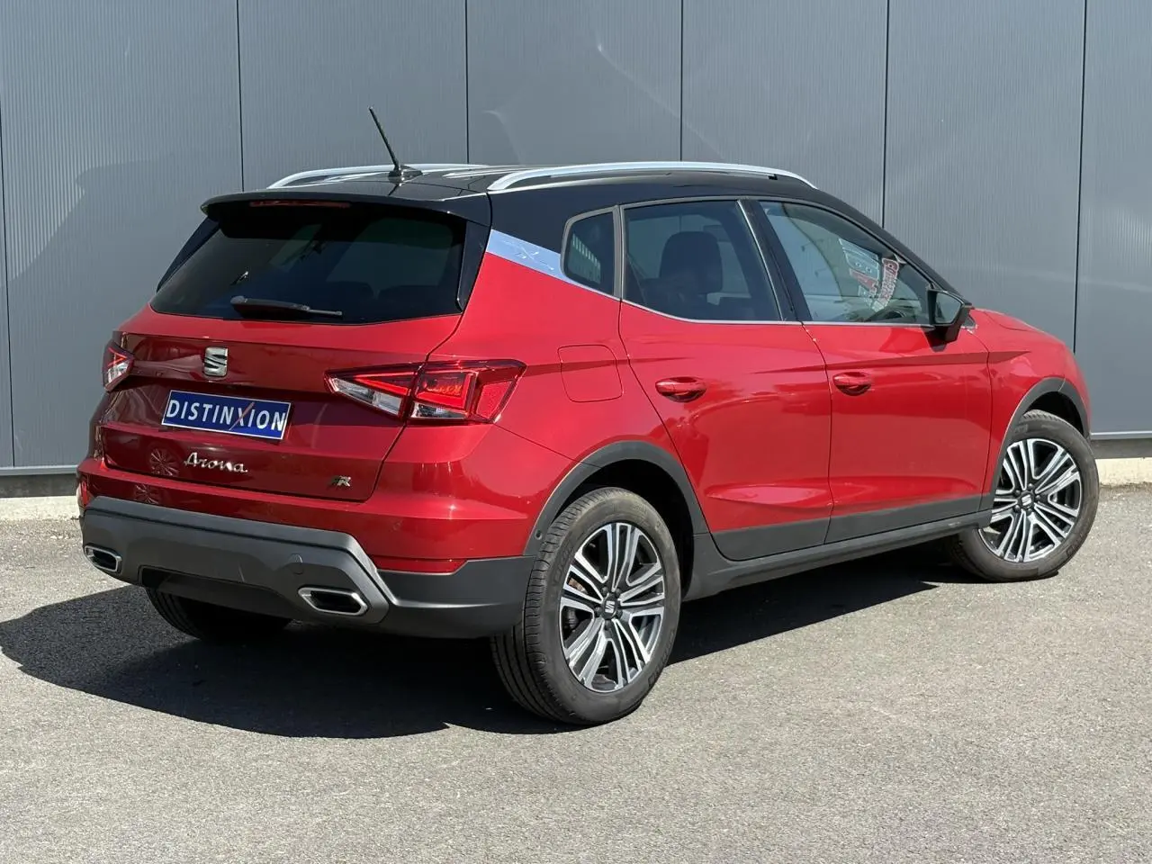 Vue 3/4 arrière droite du SEAT Arona TSI 110 FR rouge Désir avec toit noir contrasté et jantes alliage 17 pouces.