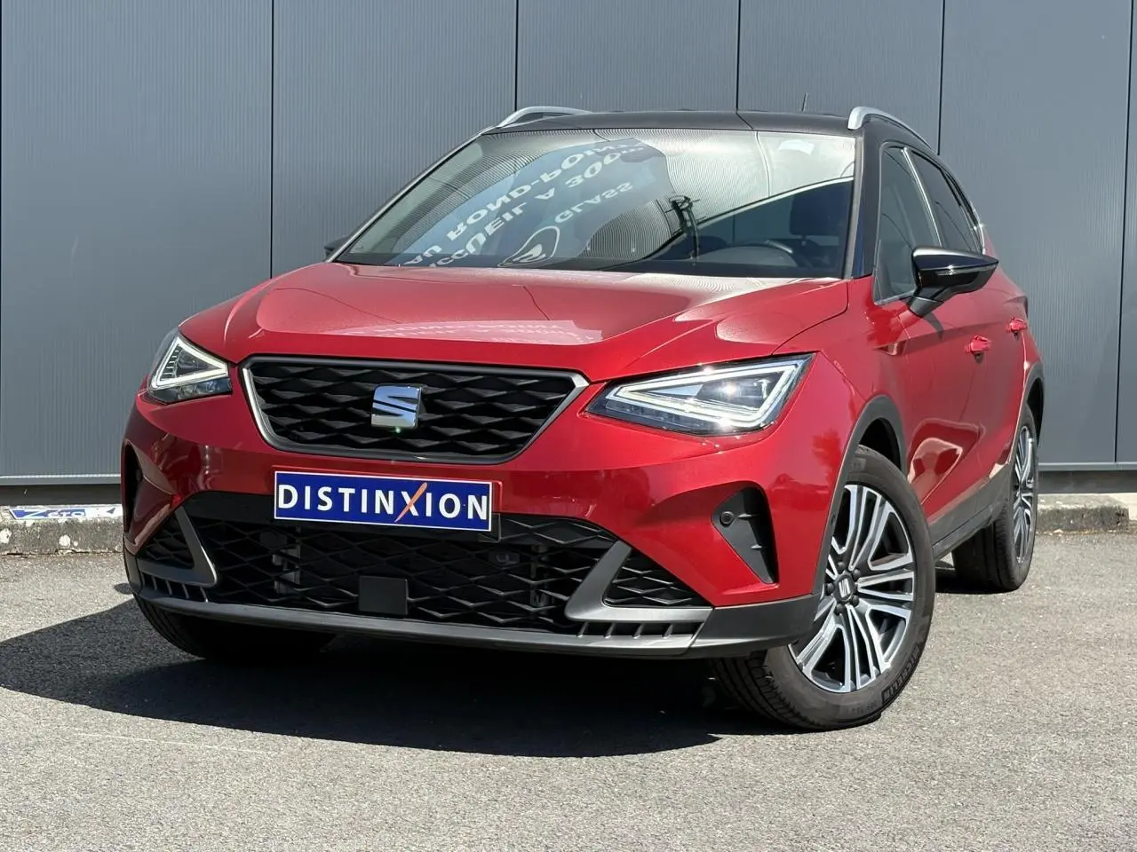 Vue 3/4 avant d'une SEAT Arona TSI 110 FR rouge Désir avec toit noir et jantes alliage 17 pouces.