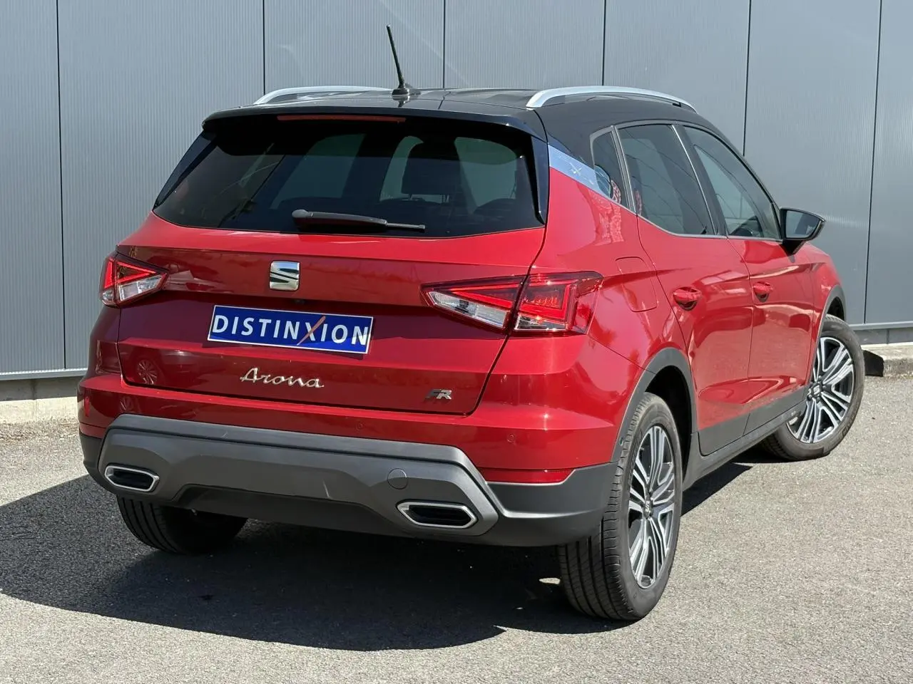 Vue 3/4 arrière droite d'un SEAT Arona TSI 110 FR rouge Désir avec toit noir et jantes alliage 17 pouces.