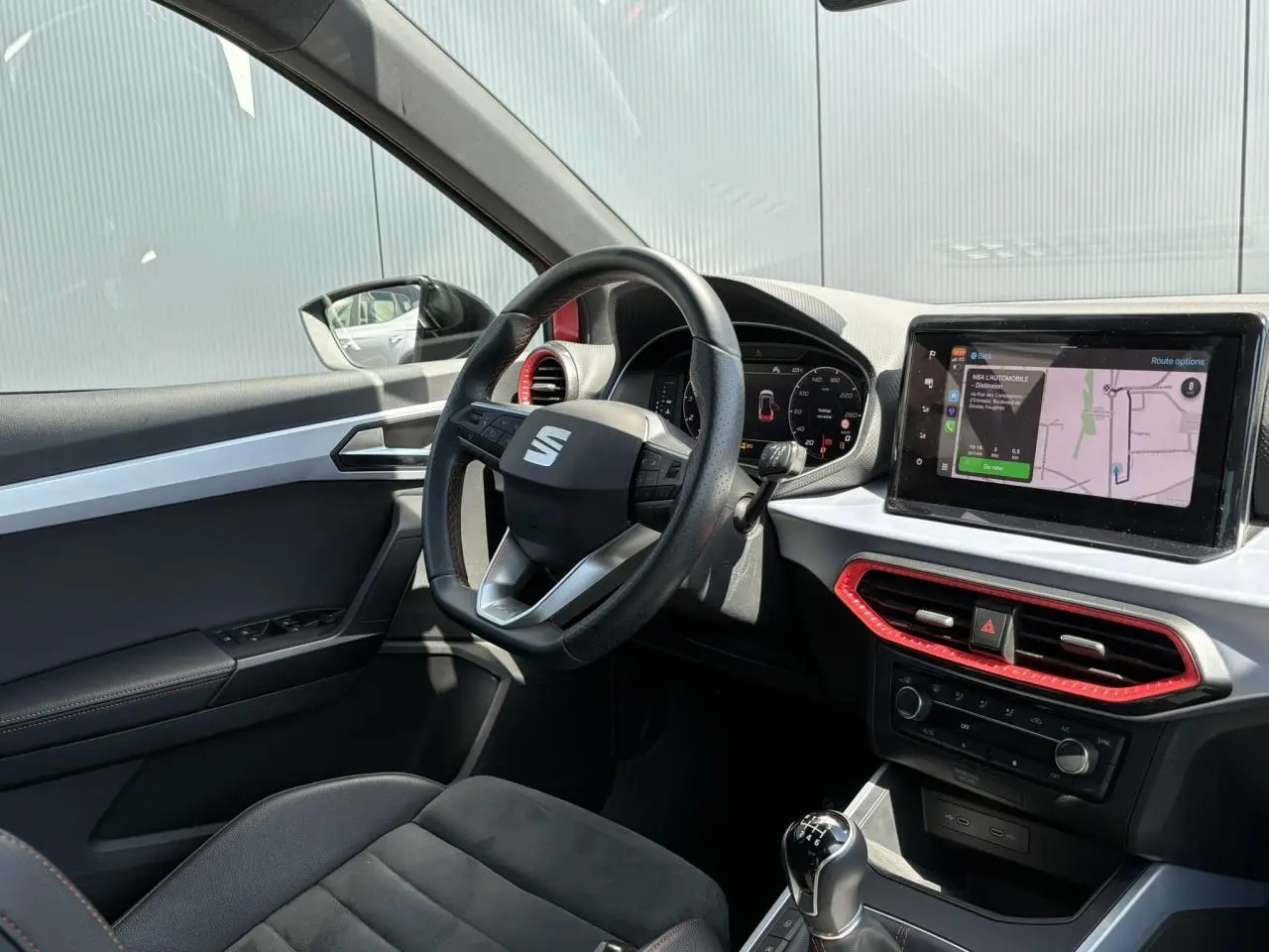 Intérieur côté conducteur du SEAT Arona TSI 110 FR 2024, avec volant multifonction, écran tactile et sellerie noire en suédine.