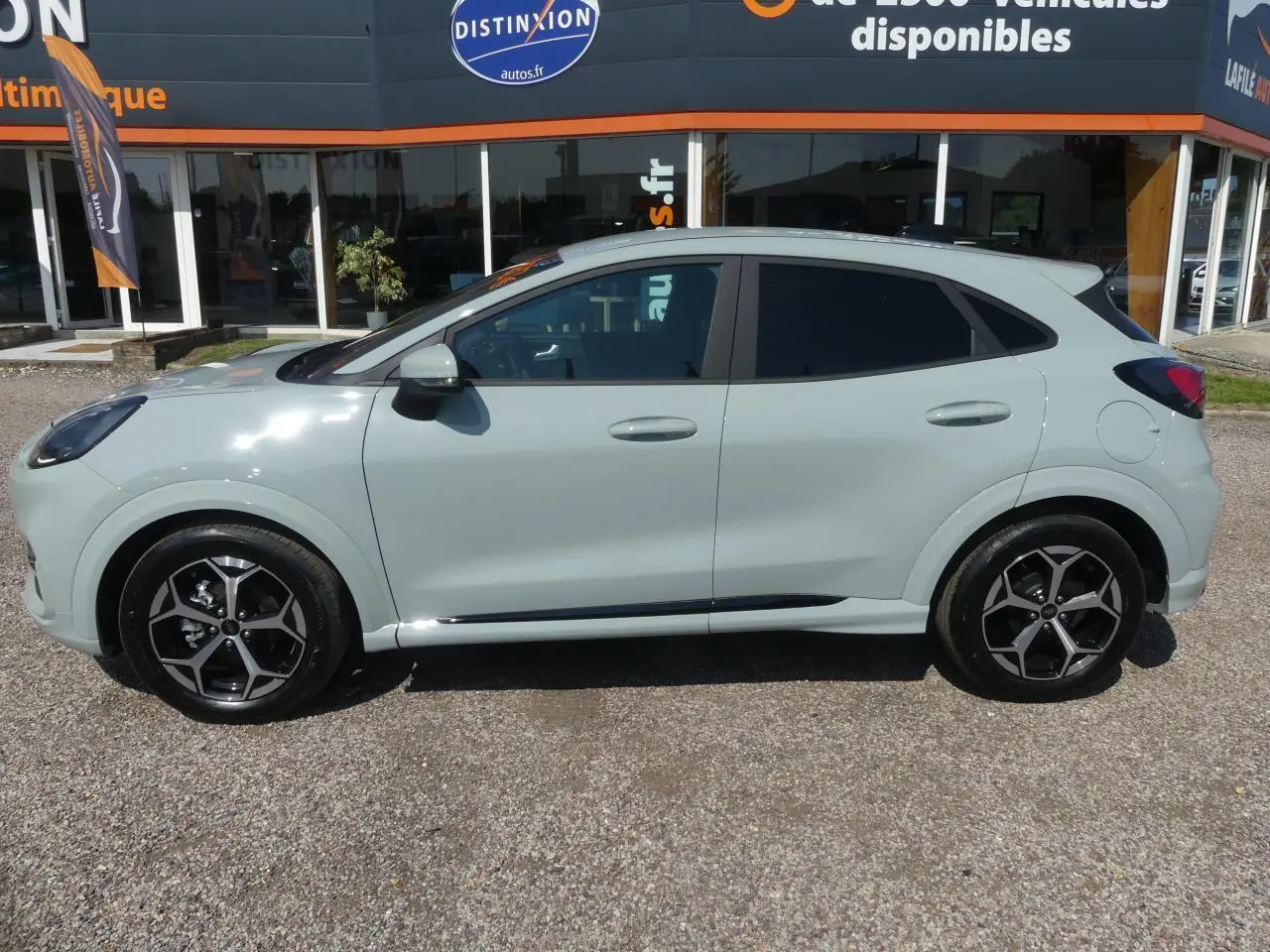 Profil côté gauche d'un Ford Puma 2025 gris clair avec jantes alliage 17 pouces et vitres arrière surteintées.