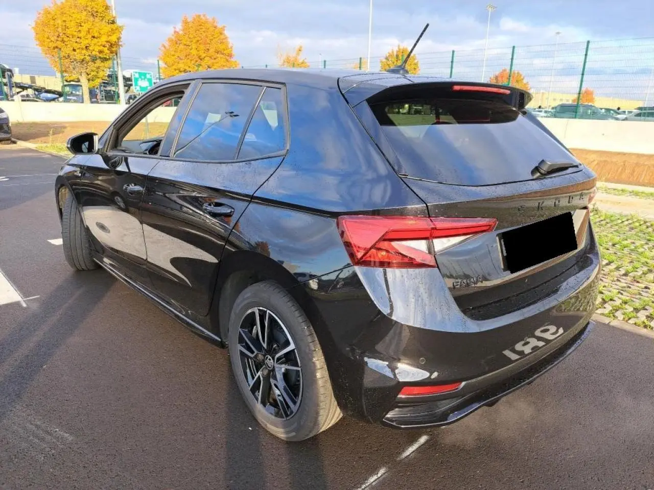 Vue 3/4 arrière gauche d'une Skoda Fabia Monte Carlo 2024 en noir Magic avec jantes noires et feux arrière LED.