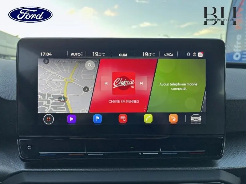 Écran tactile central avec navigation et radio dans l'habitacle d'une SEAT LEON ST gris urbain métal, vue de face.