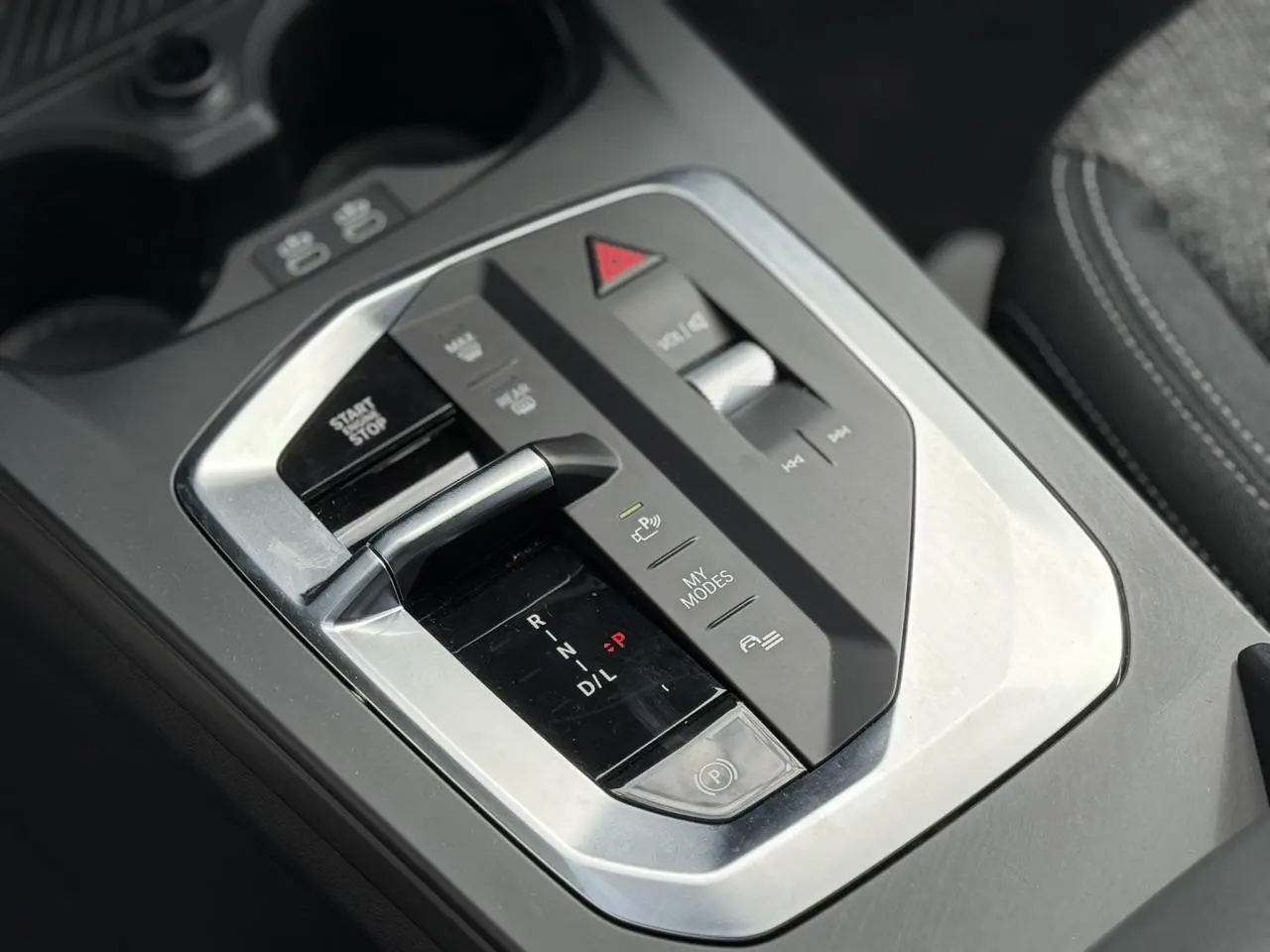 Gros plan sur la console centrale de la BMW Série 1 118d M Sport 2025, avec levier de boîte auto et commandes multifonctions.