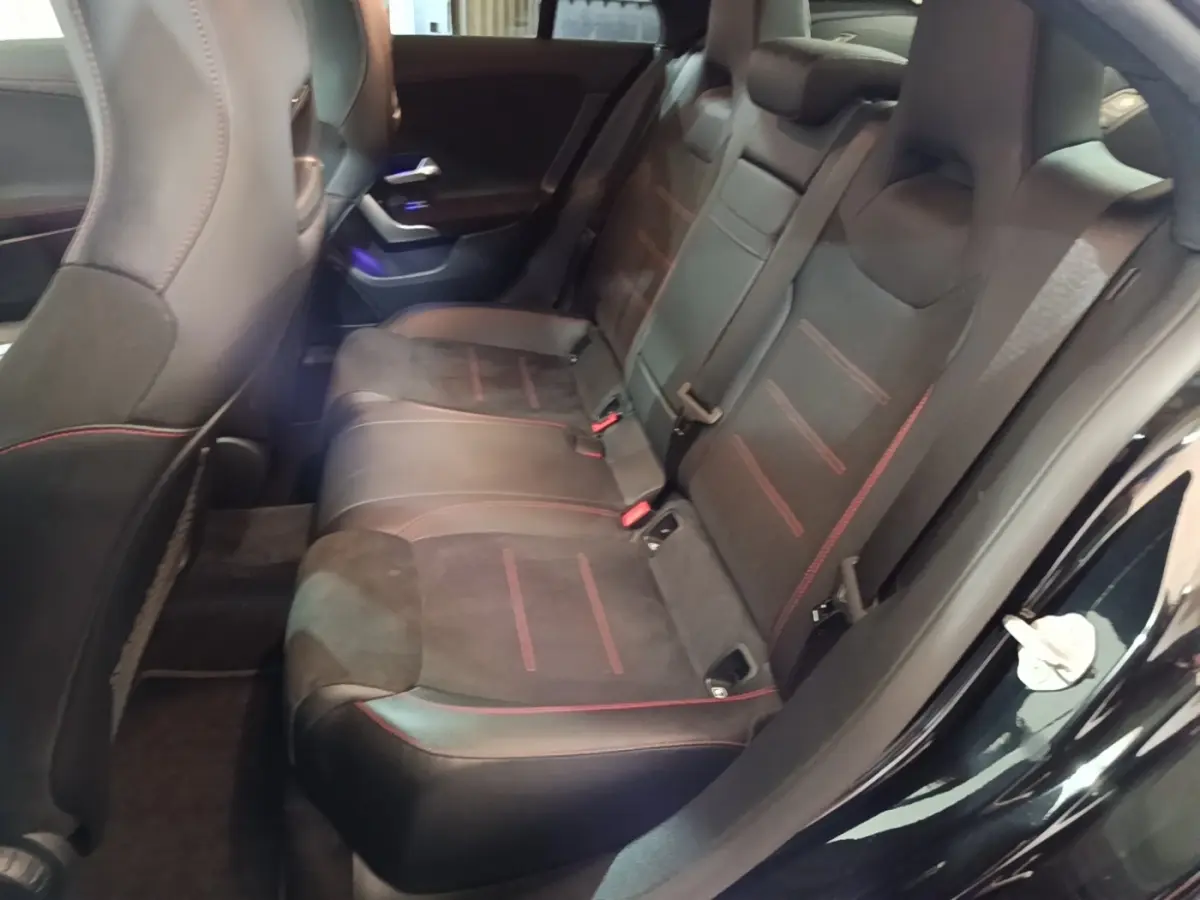 Vue intérieure côté droit des sièges arrière noirs avec surpiqûres rouges de la Mercedes CLA 200 d AMG Line 2022.