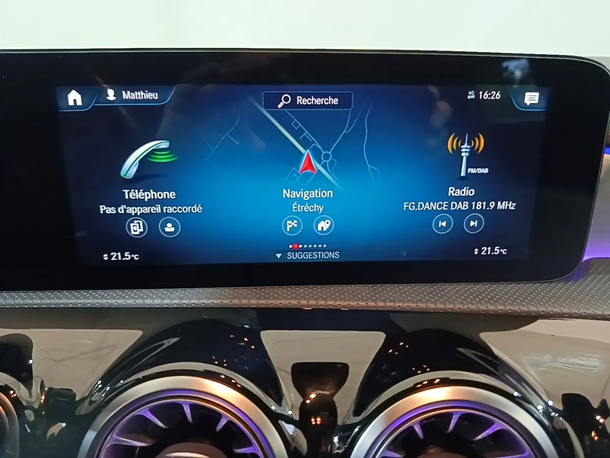 Écran tactile central du tableau de bord avec navigation, téléphone et radio dans une Mercedes CLA 200 d AMG Line noire.