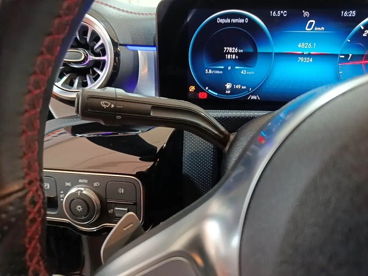 Gros plan intérieur sur le volant noir et le tableau de bord numérique bleu d'une Mercedes CLA 200 d AMG Line 2022.