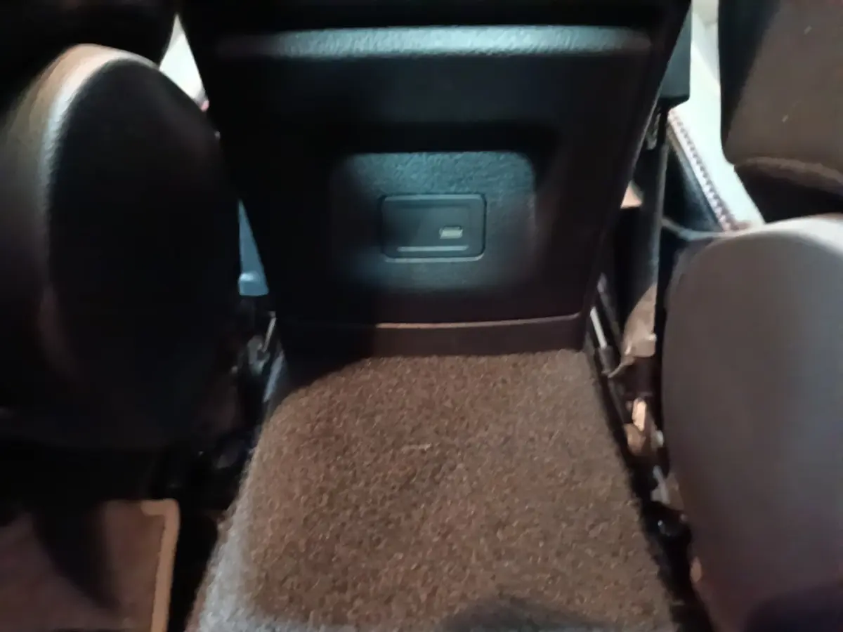 Vue rapprochée de la prise USB située à l'arrière du siège conducteur dans l'habitacle noir du Mercedes CLA 200 d AMG Line.