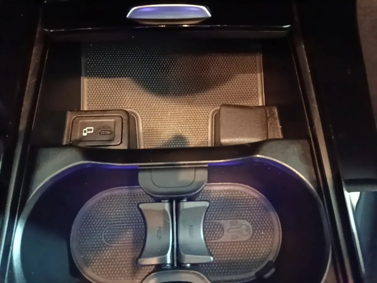Gros plan sur le porte-gobelets et prise USB du compartiment central intérieur noir de la Mercedes CLA 200 d AMG Line 2022.