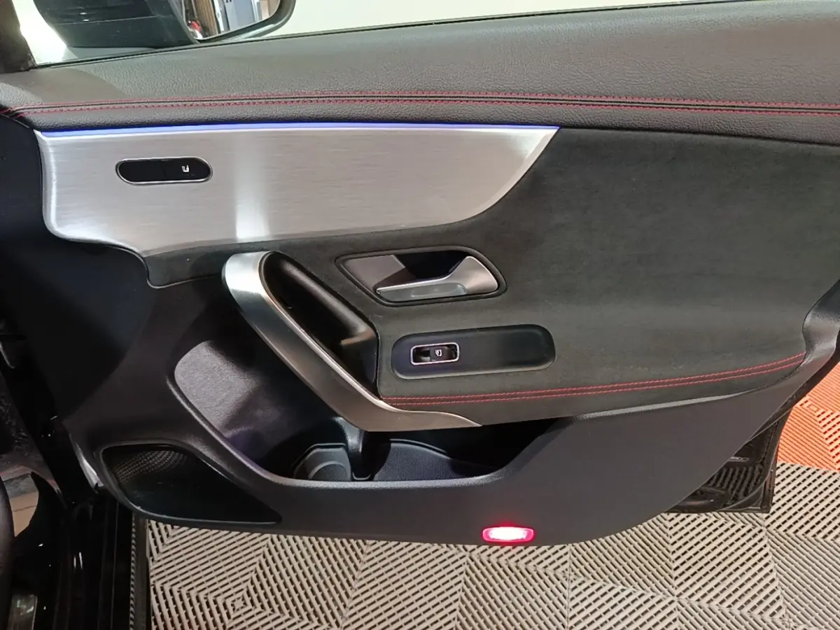 Vue intérieure du panneau de porte avant gauche noir avec surpiqûres rouges et insert aluminium brossé sur Mercedes CLA 200 d AMG Line 2022.