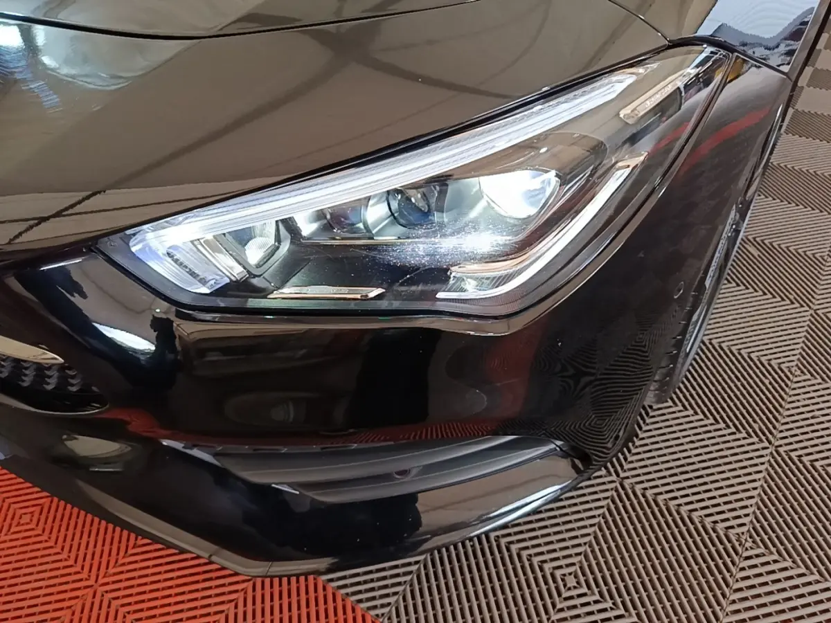 Gros plan sur le phare avant droit noir brillant d'une Mercedes CLA 200 d AMG Line 2022, détails LED visibles.