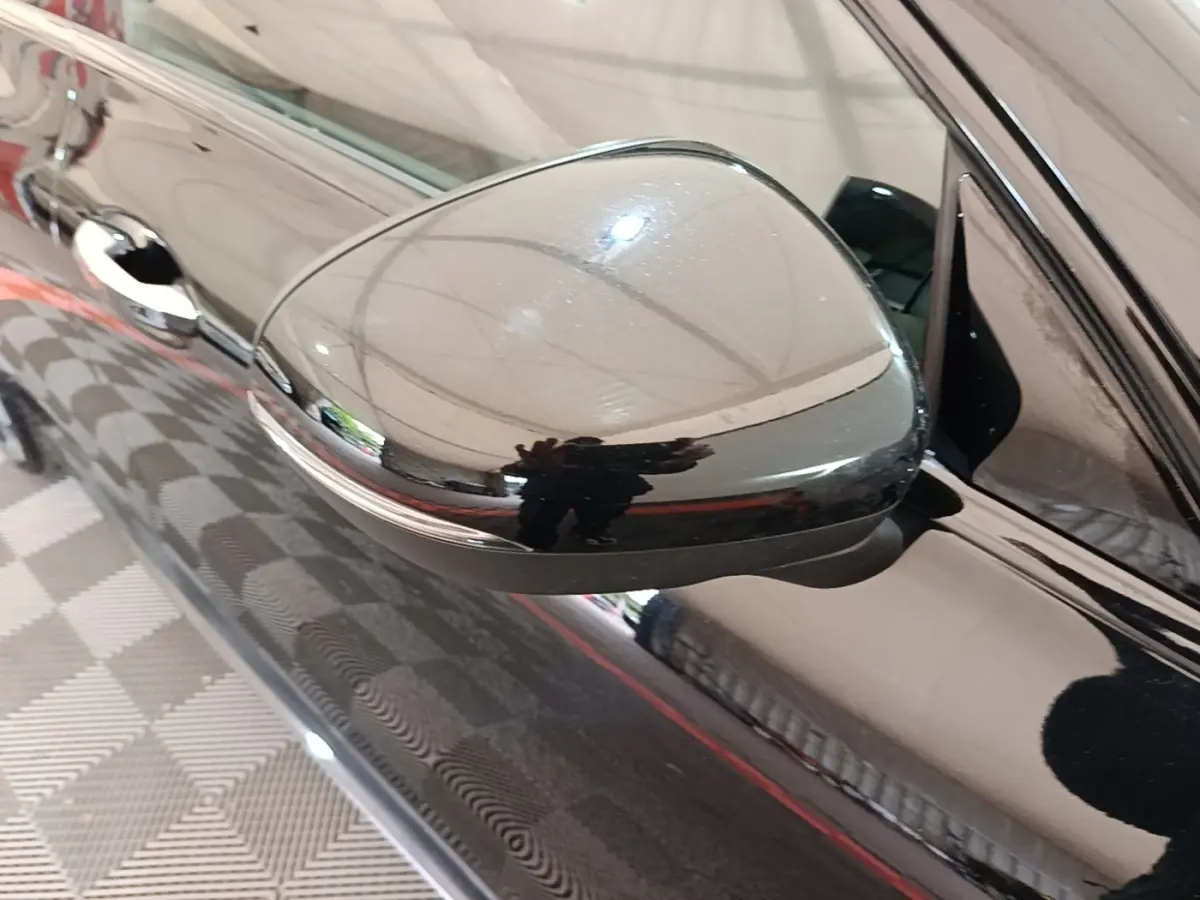Gros plan sur le rétroviseur côté gauche noir brillant d'une Mercedes CLA 200 d AMG Line 2022.