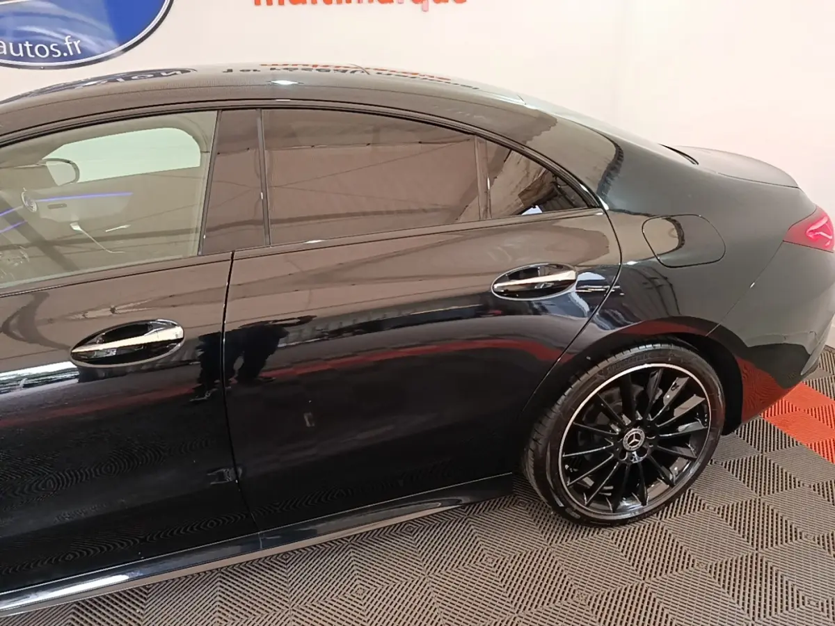 Vue latérale droite d'une Mercedes CLA 200 d AMG Line noire avec jantes alliage noires et vitres teintées.