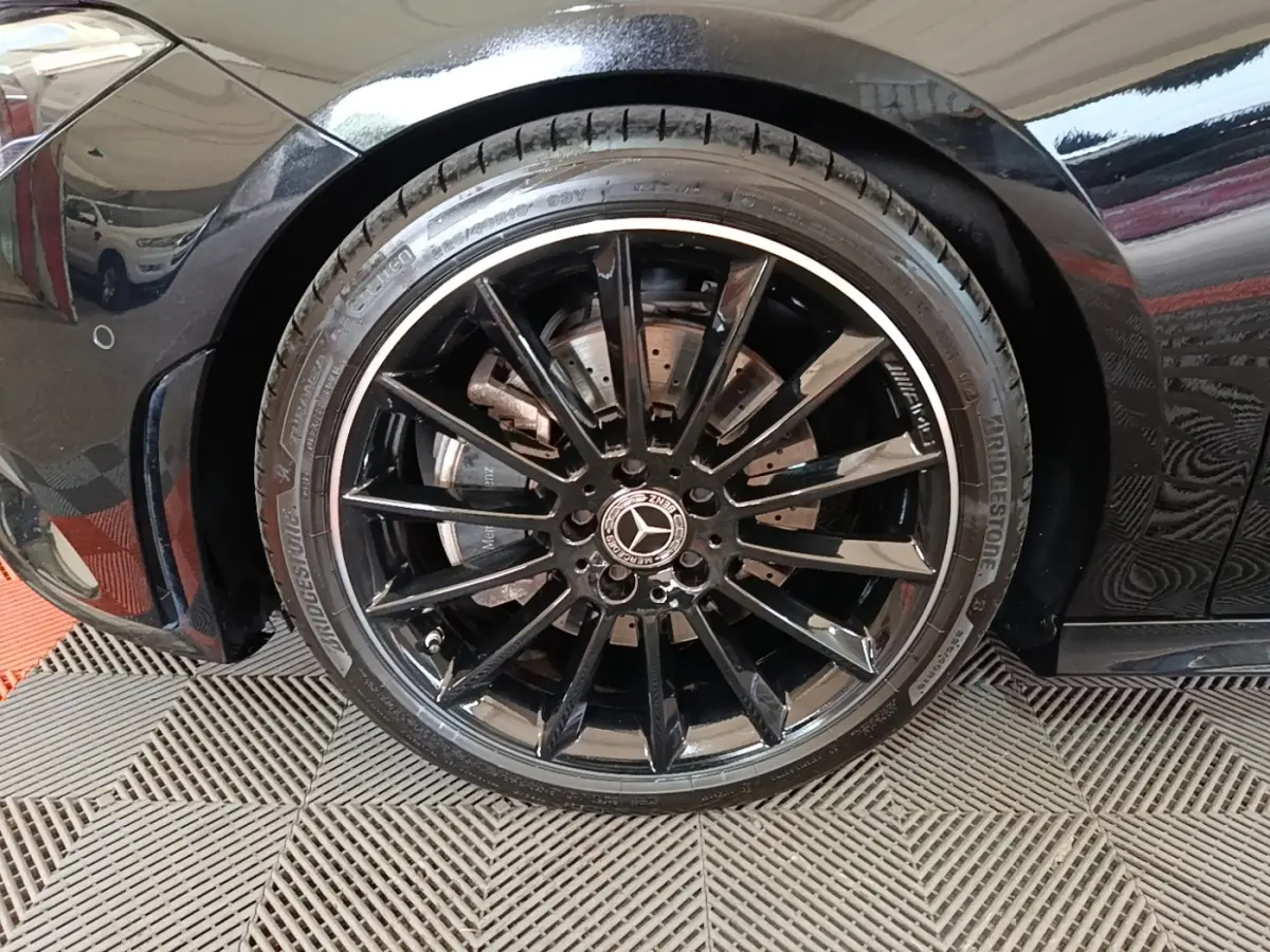Gros plan sur la roue avant gauche noire à jante AMG brillante d'une Mercedes CLA 200 d AMG Line 2022.
