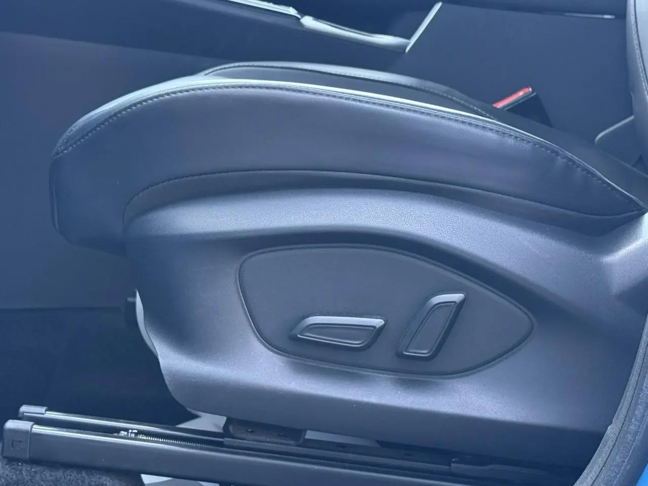 Gros plan sur les commandes de réglage électrique du siège avant en tissu/similicuir noir du MG ZS 1.5 Hybrid+ 197 Luxury 2025.