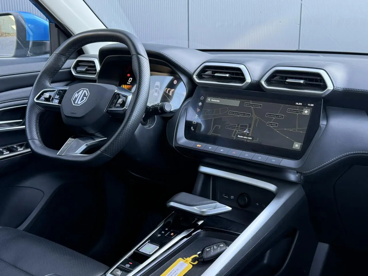 Vue intérieure côté conducteur du MG ZS 1.5 Hybrid+ 197 Luxury 2025, avec tableau de bord noir et écran tactile de navigation.
