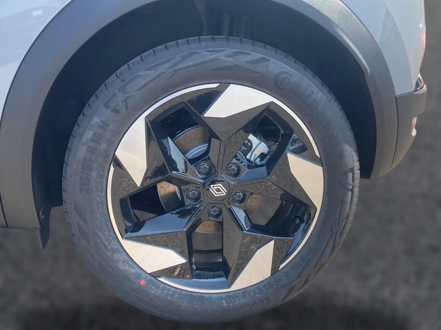 Gros plan sur la jante alu noire et argentée du Renault Captur 1.2 TCe 115 Techno, roue avant côté gauche.