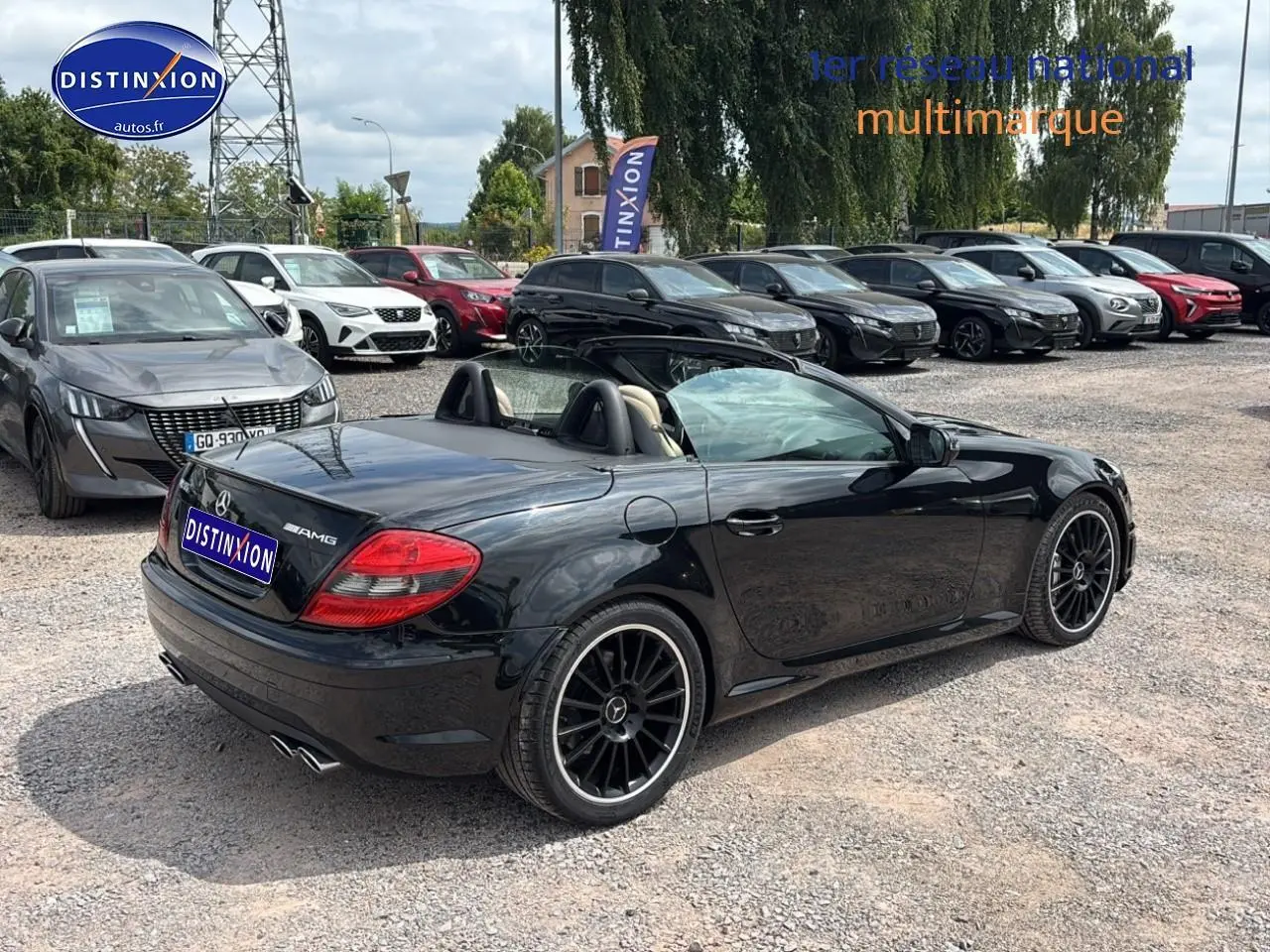 Mercedes SLK 55 AMG noir vue 3/4 arrière droit cabriolet avec jantes alu noires sur parking multimarque