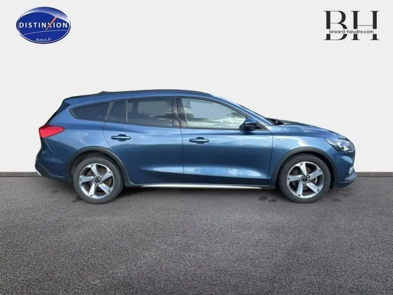 Ford Focus 1.5 EcoBlue Business bleu azur métallisé vue de profil côté gauche avec jantes alu et vitres arrière surteintées.