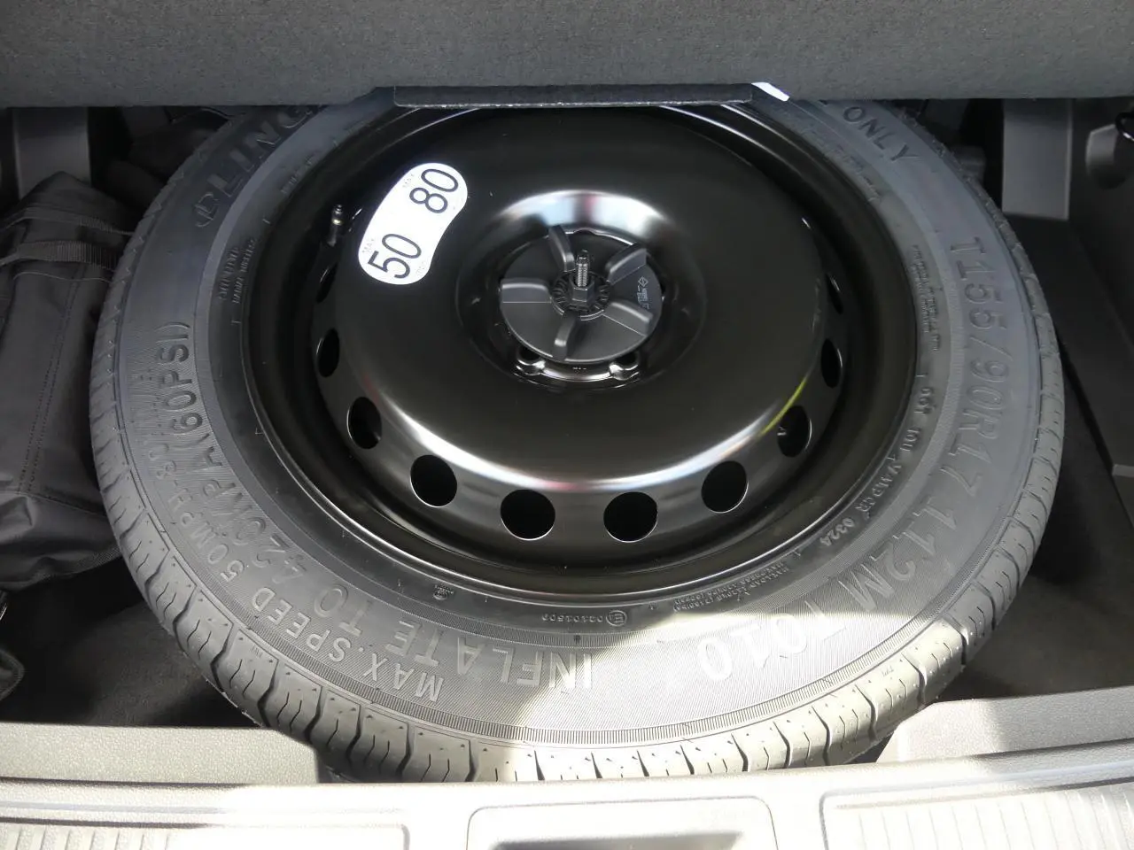 Roue de secours galette noire dans le coffre du Renault Austral gris métallisé 2025, vue en plongée rapprochée.