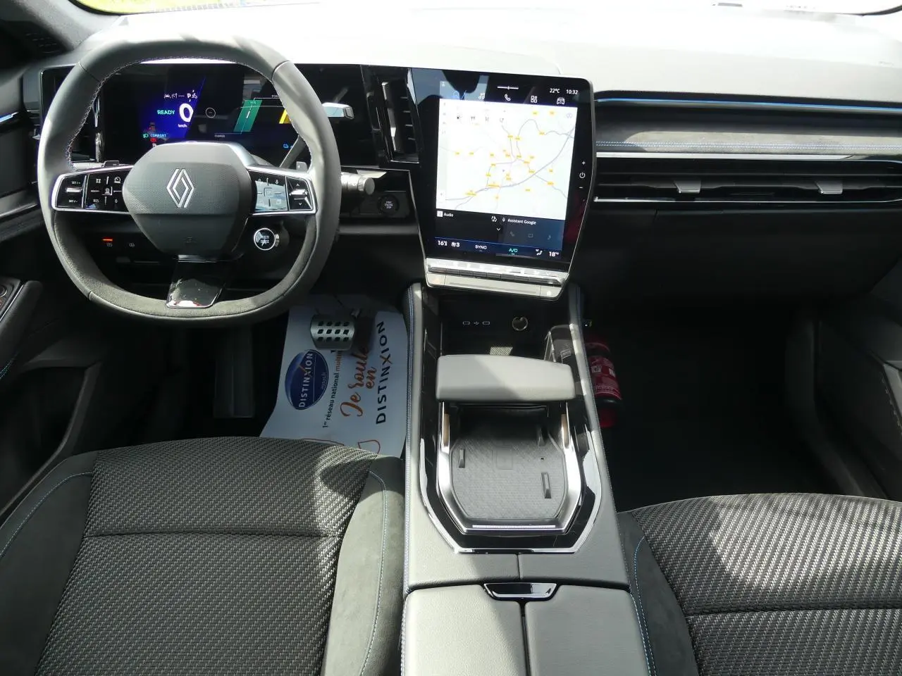 Intérieur Renault Austral 2025 vu de face, tableau de bord moderne avec écran tactile vertical et volant Alcantara noir.