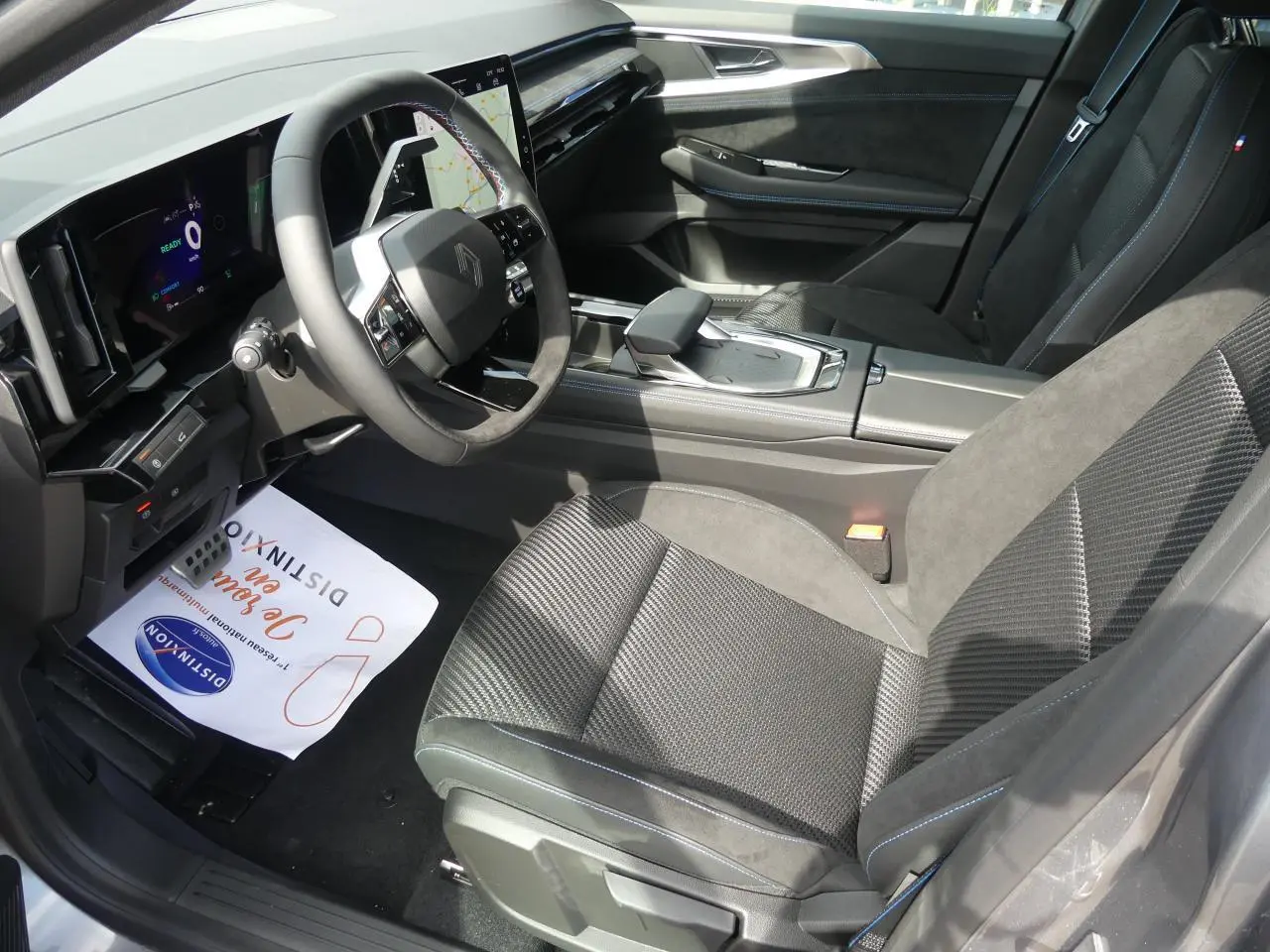 Vue intérieure côté conducteur du Renault Austral 2025 gris métallisé, avec volant Alcantara et tableau de bord numérique.