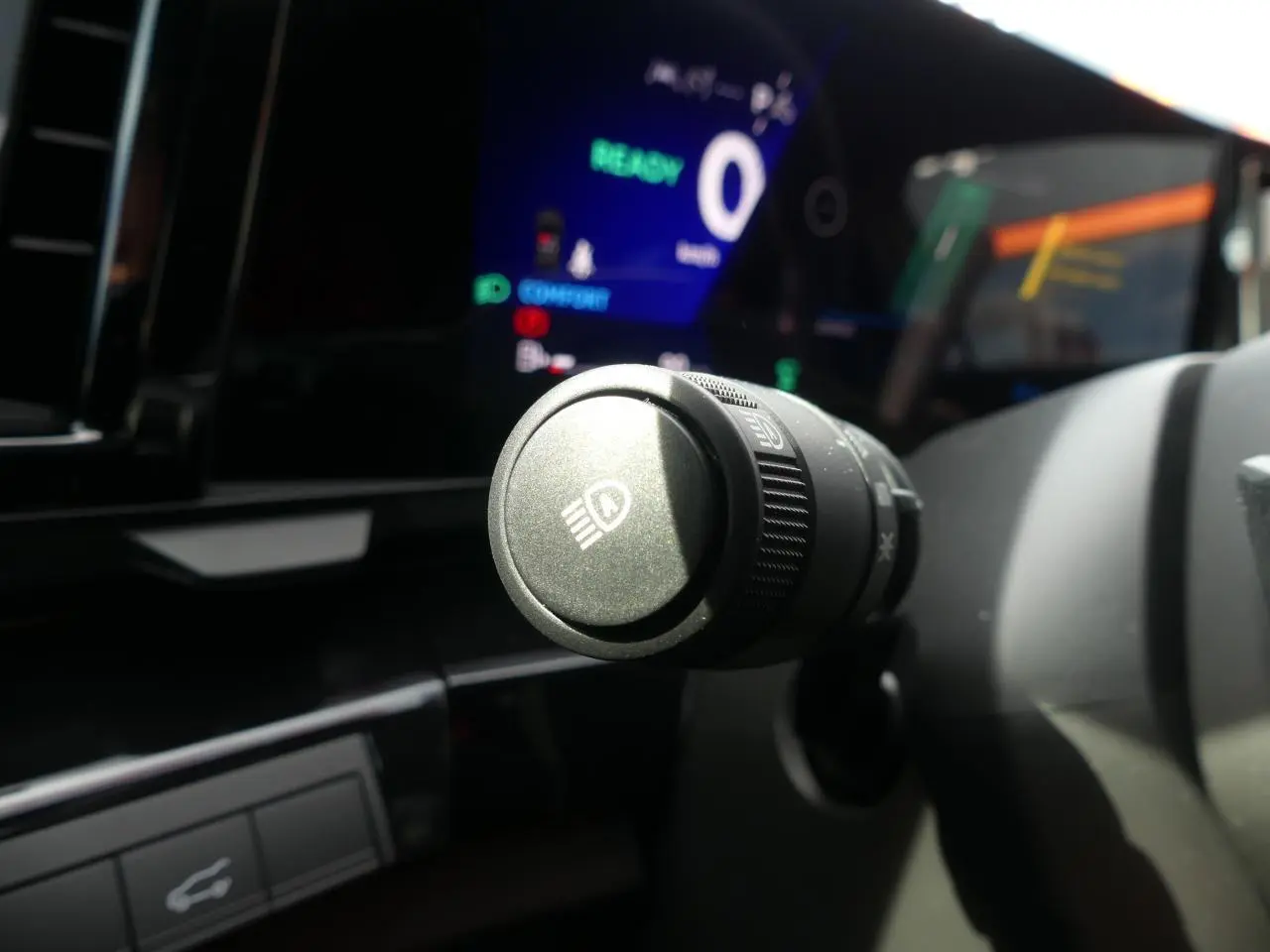 Gros plan sur la commande des feux du tableau de bord du Renault Austral 2025, intérieur noir moderne.