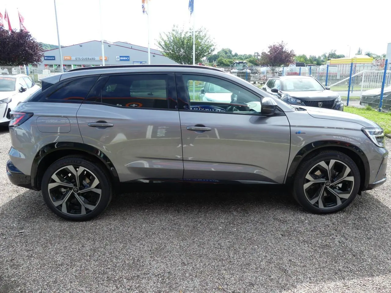 Profil côté gauche d'un Renault Austral gris métallisé avec jantes alliage 20 pouces et vitres teintées arrière.