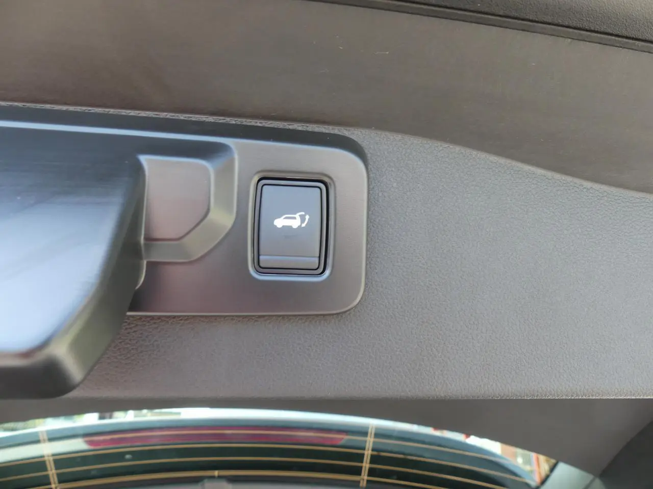 Bouton d'ouverture mains-libres du hayon sur le gris métallisé Renault Austral 2025, vue intérieure du coffre.