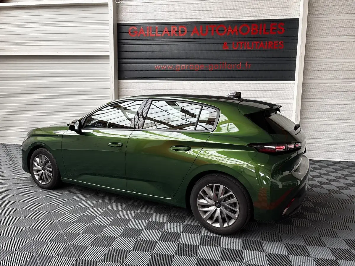 Peugeot 308 PureTech 110 S&S ACTIVE PACK vert vue de profil côté gauche dans un showroom avec sol damier.