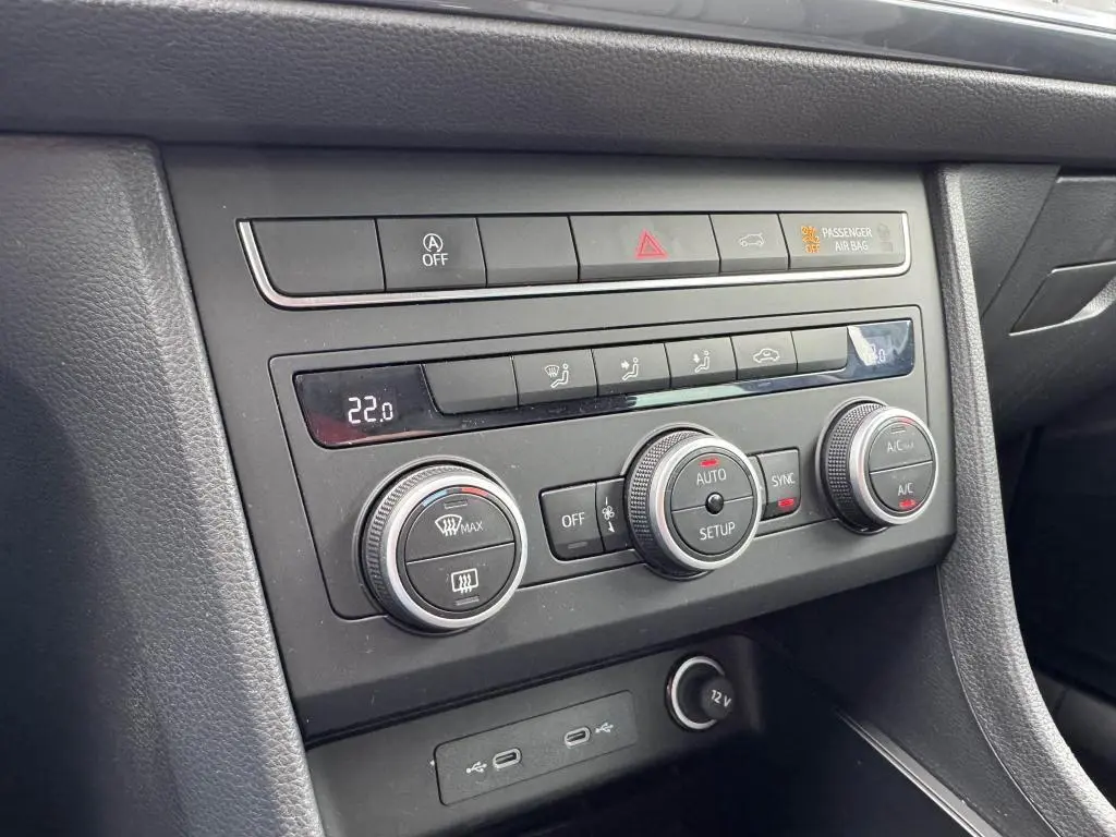 Vue rapprochée de la console centrale noire du SEAT Ateca 2023, avec commandes climatisation et prises USB-C éclairées.