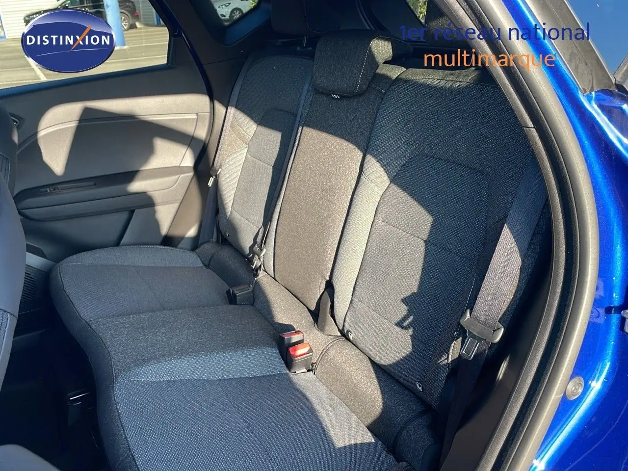 Vue côté droit des sièges arrière en tissu gris du Renault Captur E-Tech Hybrid 2025 bleu iron metal avec toit gris.