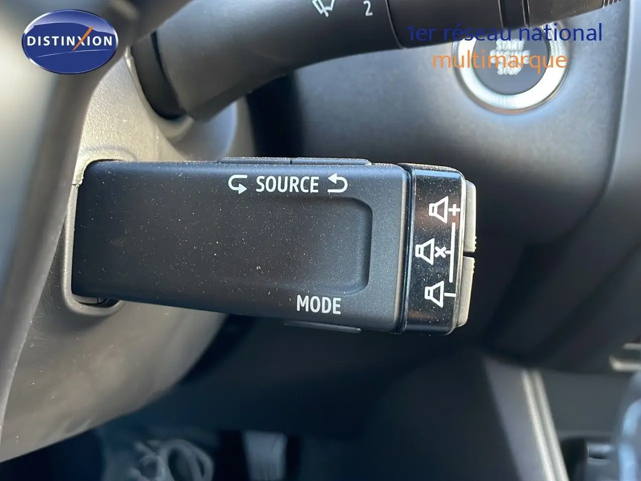 Gros plan sur la commande au volant du Renault Captur E-Tech Hybrid 2025, avec bouton source et mode visibles.