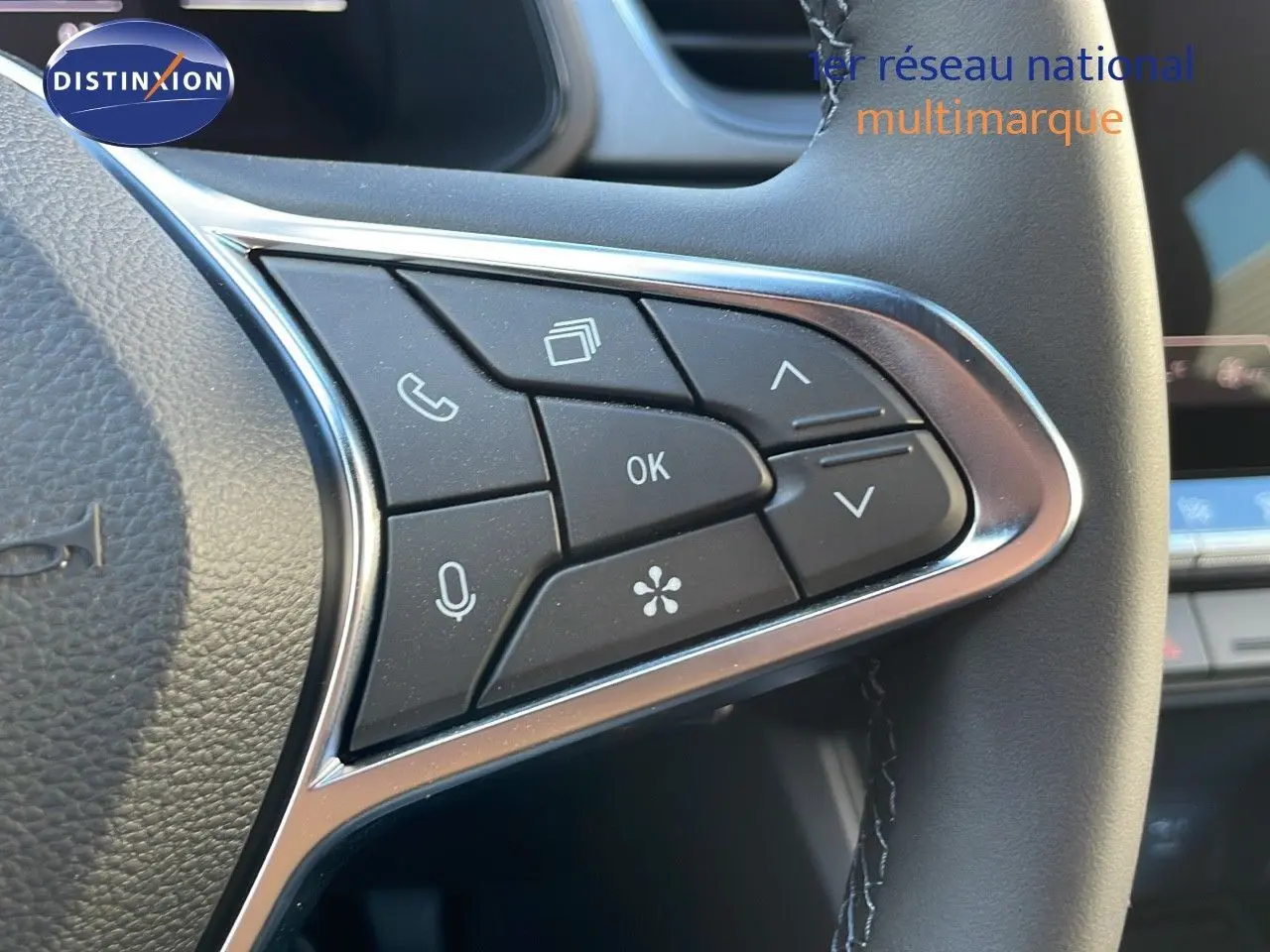 Gros plan sur les commandes multifonctions du volant noir du Renault Captur E-Tech Hybrid 2025, finition Techno.