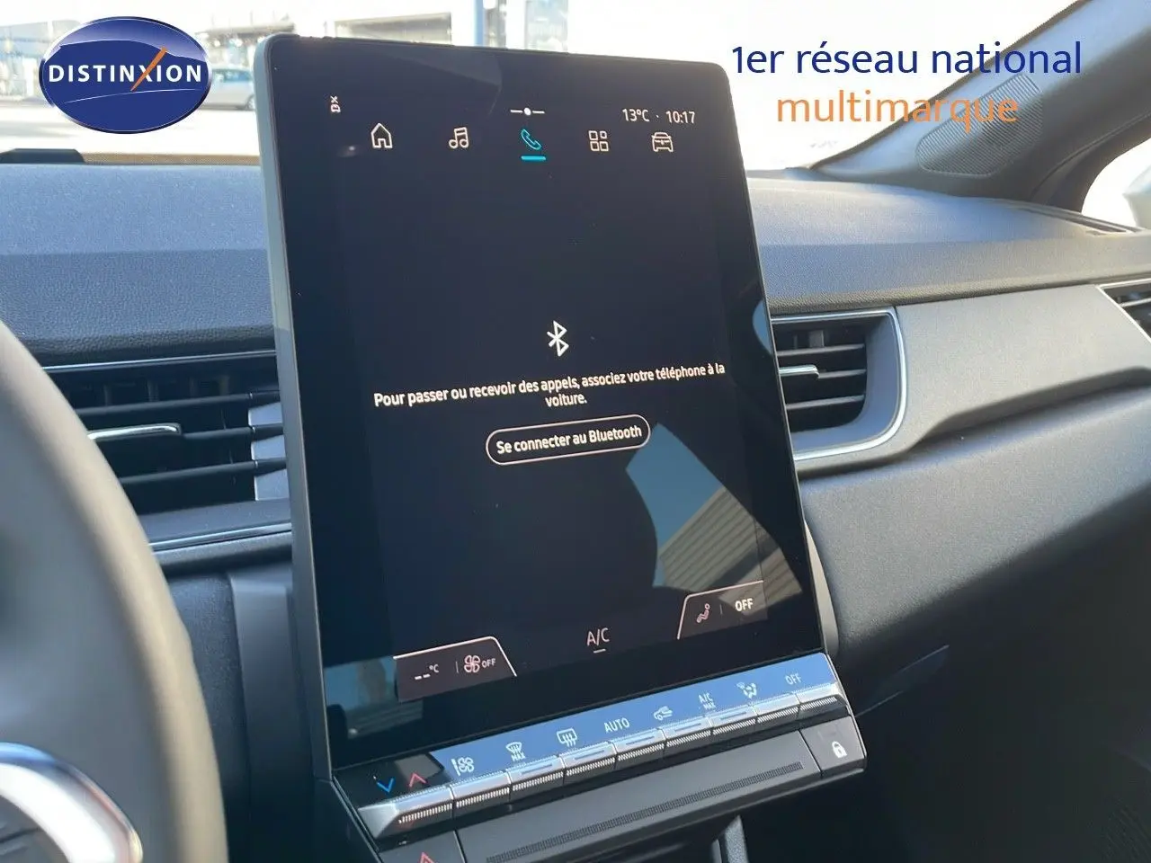 Vue rapprochée de l'écran tactile central du tableau de bord du Renault Captur bleu iron métal avec toit gris.