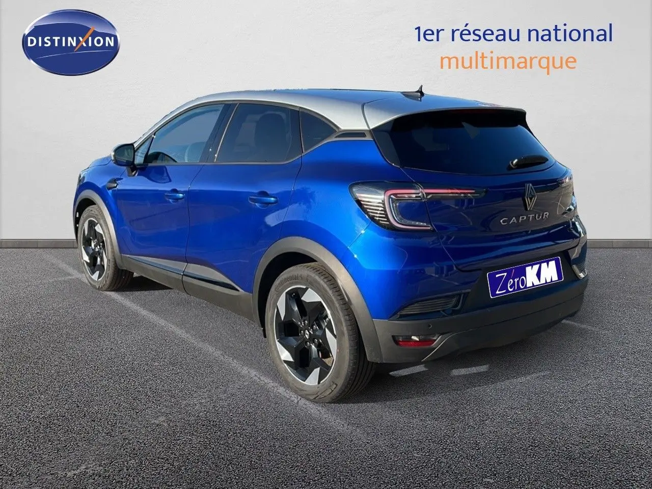 Renault Captur E-Tech hybride bleu Iron métal avec toit gris, vu de trois quarts arrière côté gauche.